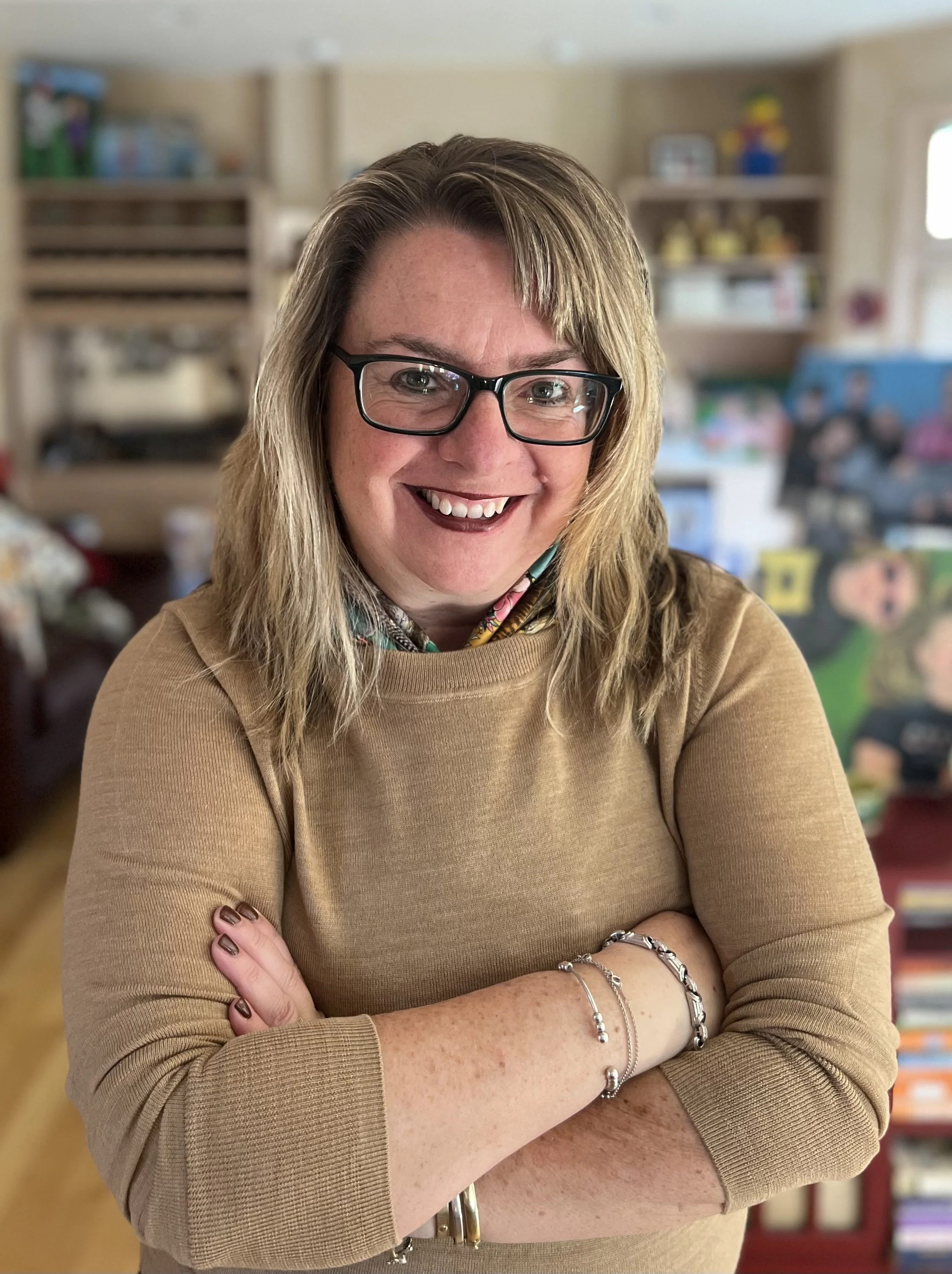 Author, storyteller, romance writer, adult white woman with blonde hair, wearing glasses, smiling