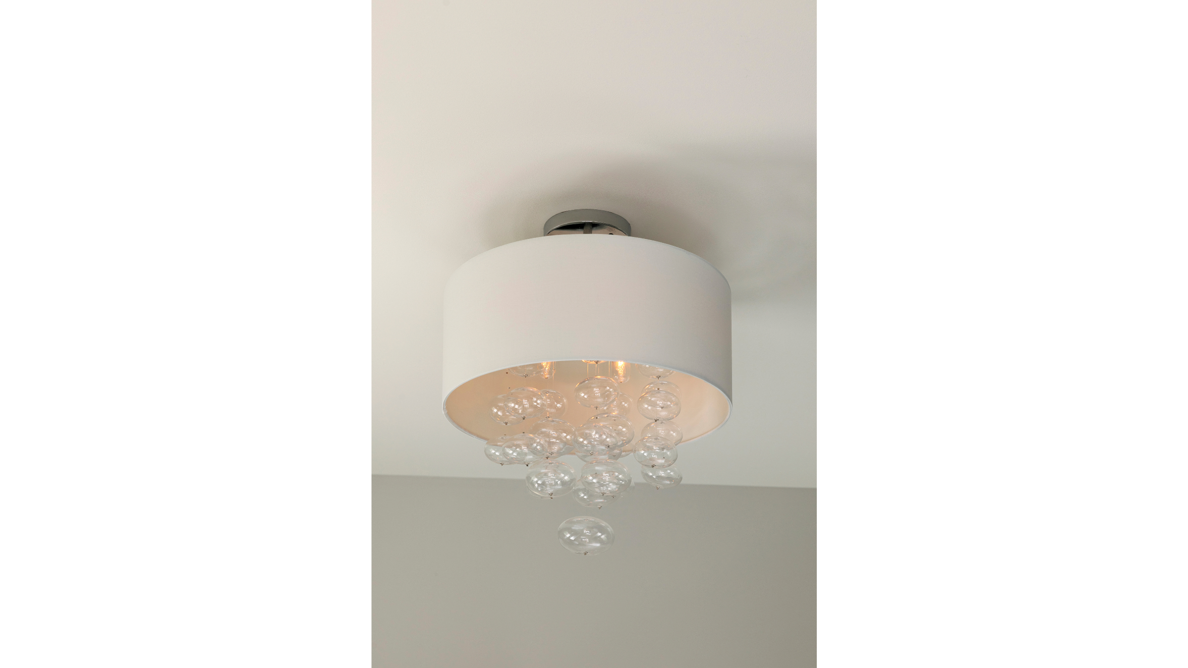 Ceiling light fixture with a white drum shade and clear glass bubbles hanging inside.
