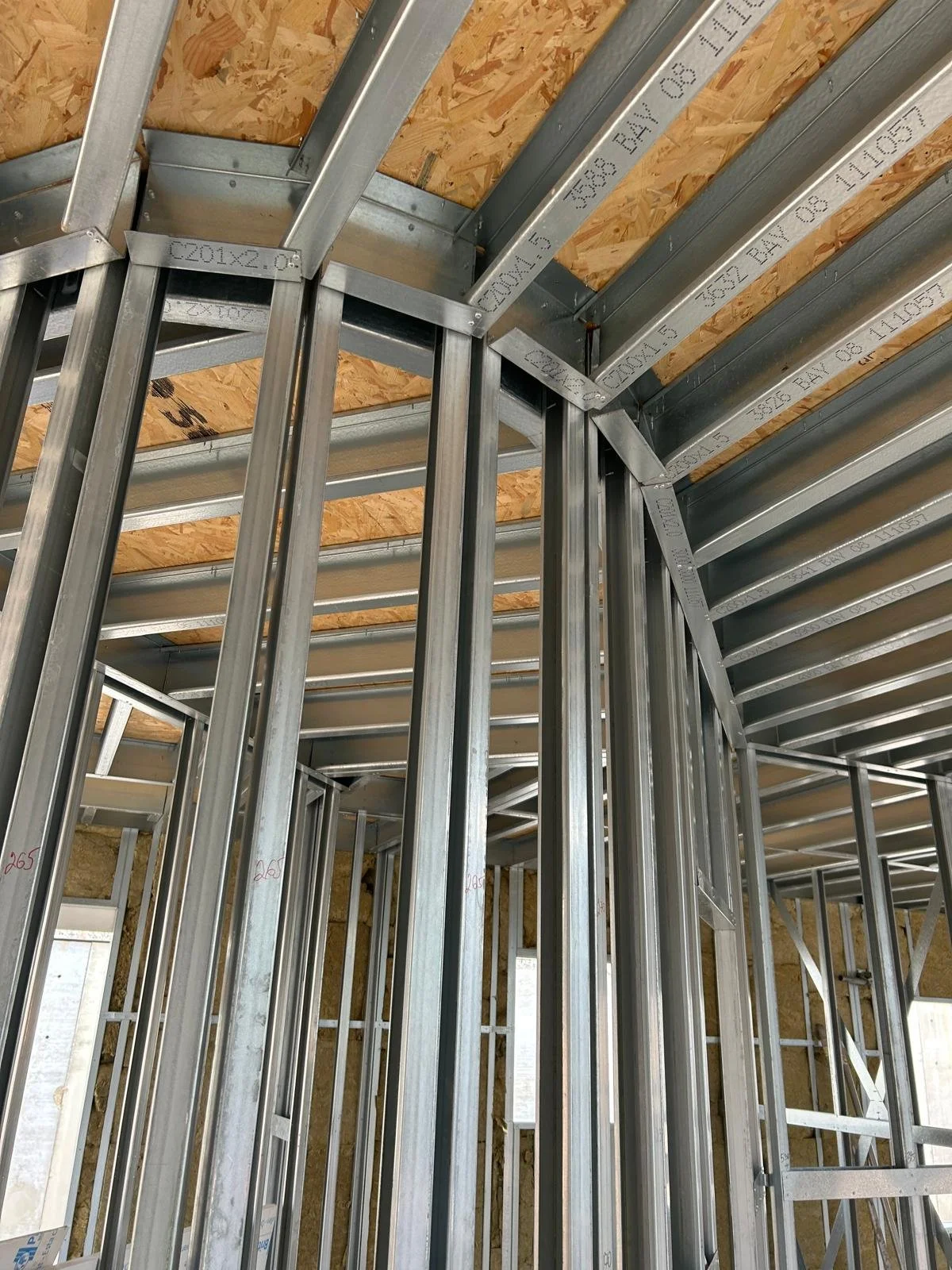 Metal framing for walls and ceiling under construction inside a building.