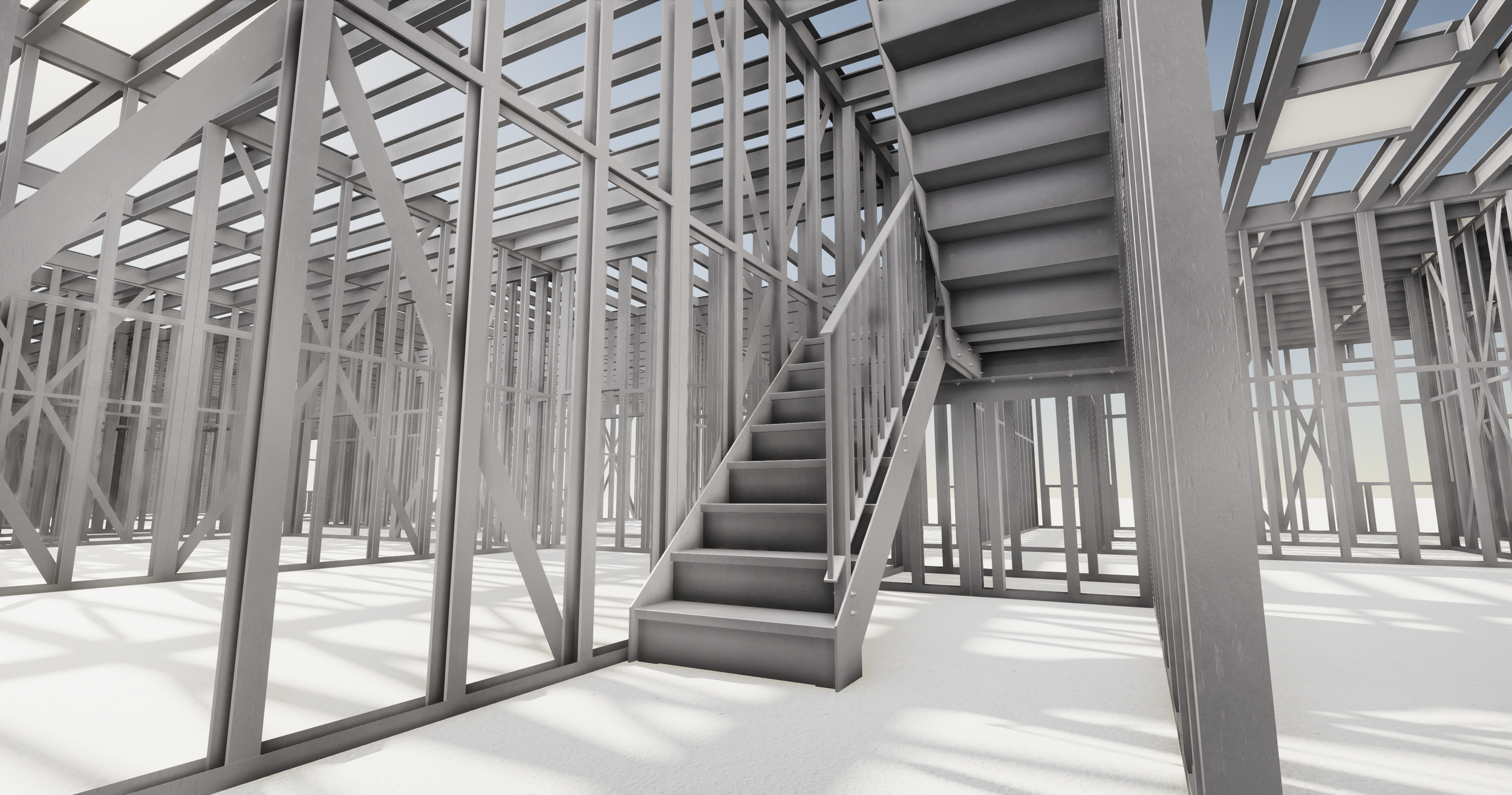 Interior view of an unfinished building with exposed metal framing and a staircase leading to an upper level.