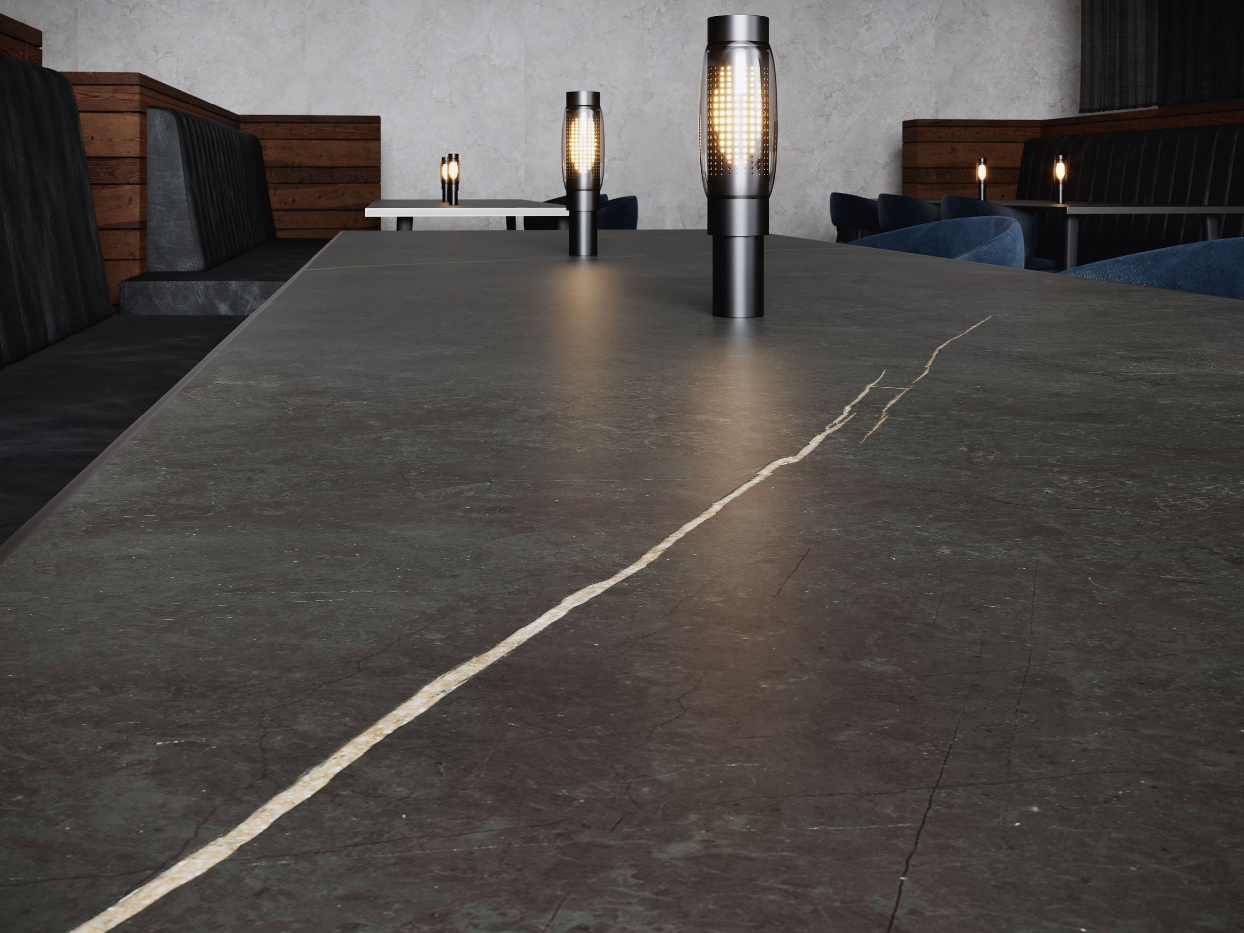 Close-up of a dark, cracked marble dining table with modern black lamps and blue chairs in a restaurant.