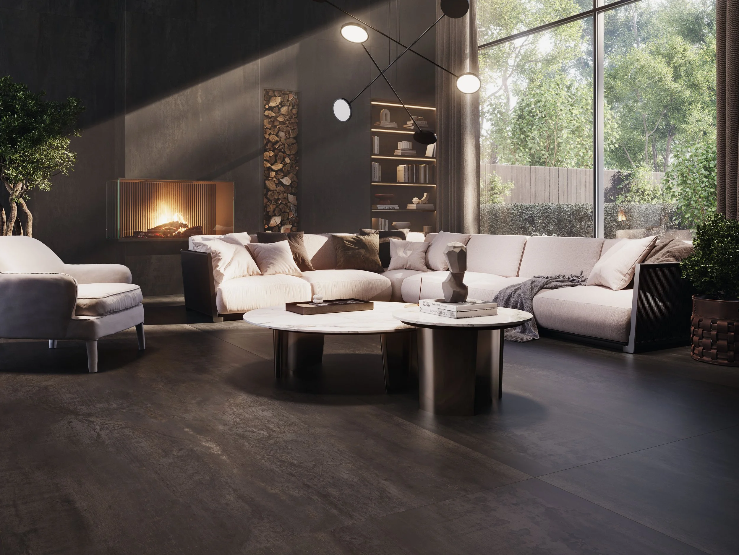 Modern living room with a white sectional sofa, armchair, round marble coffee tables, fireplace, bookshelf, large window with curtains, and outdoor greenery.