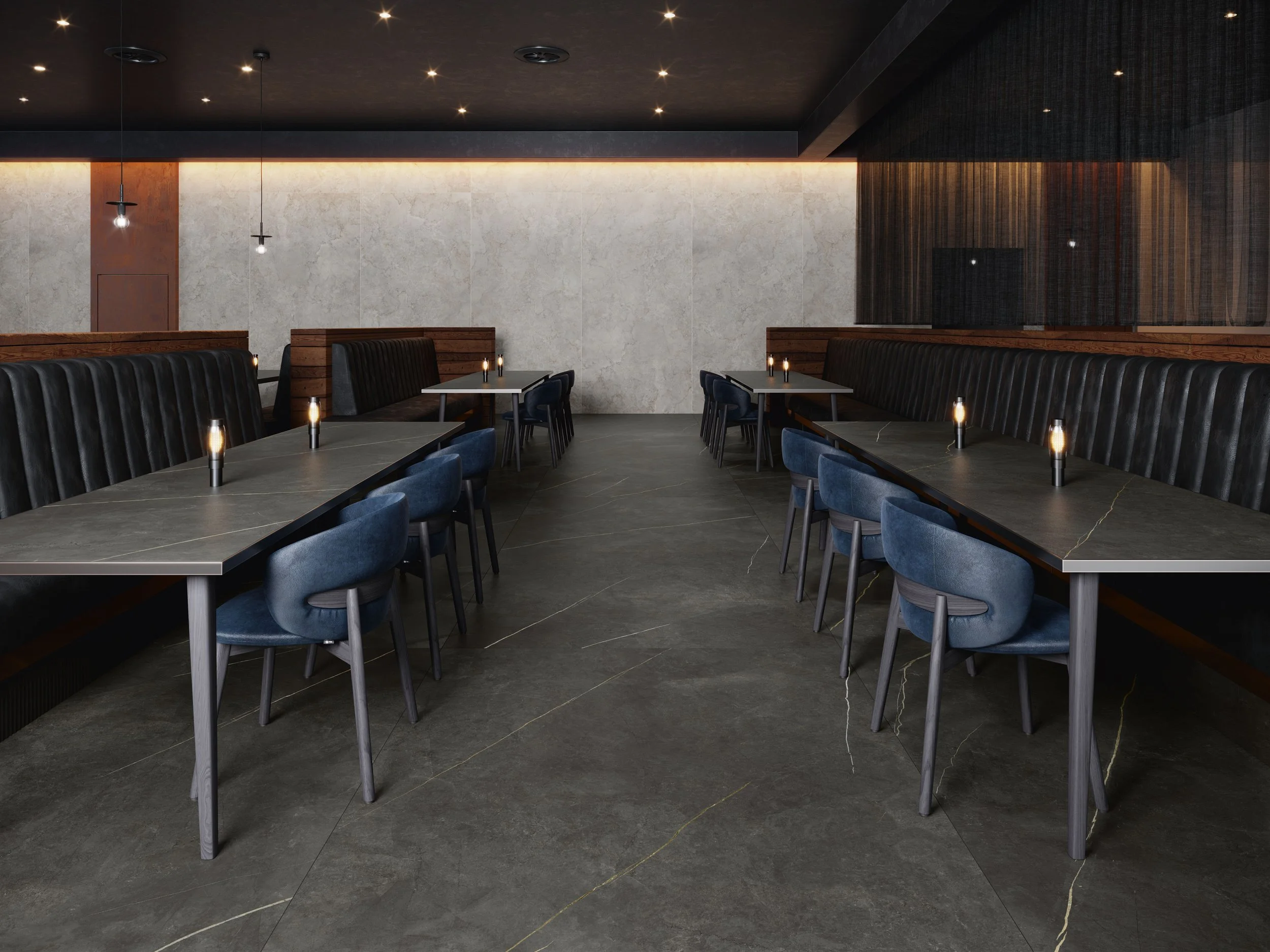 Modern restaurant interior with black and blue seating, long tables, candles, and dim lighting.