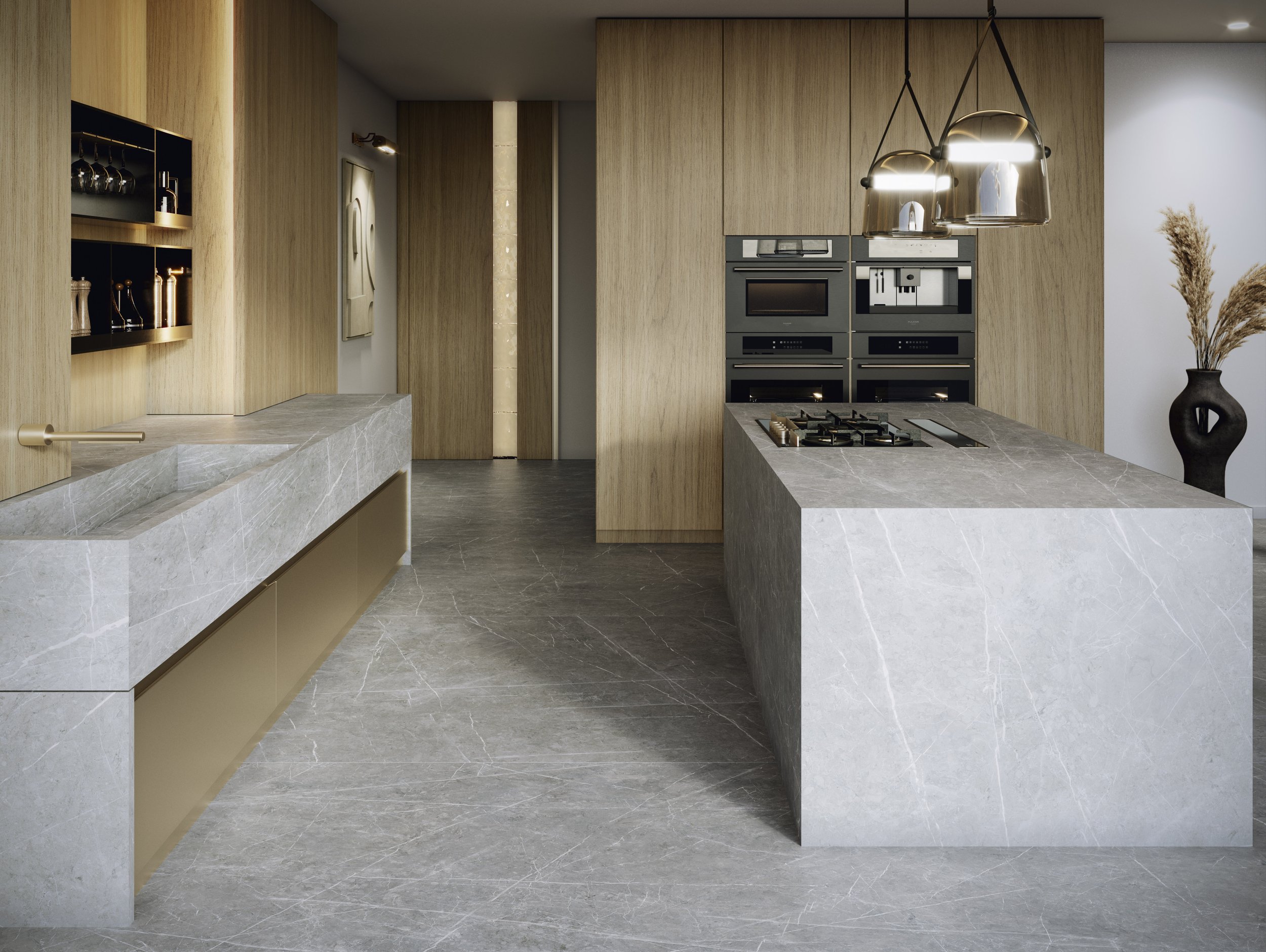 Modern kitchen with light wood cabinets, gray marble countertops, built-in black appliances, and pendant lights hanging over the island, with a black vase holding dried plants in the corner.