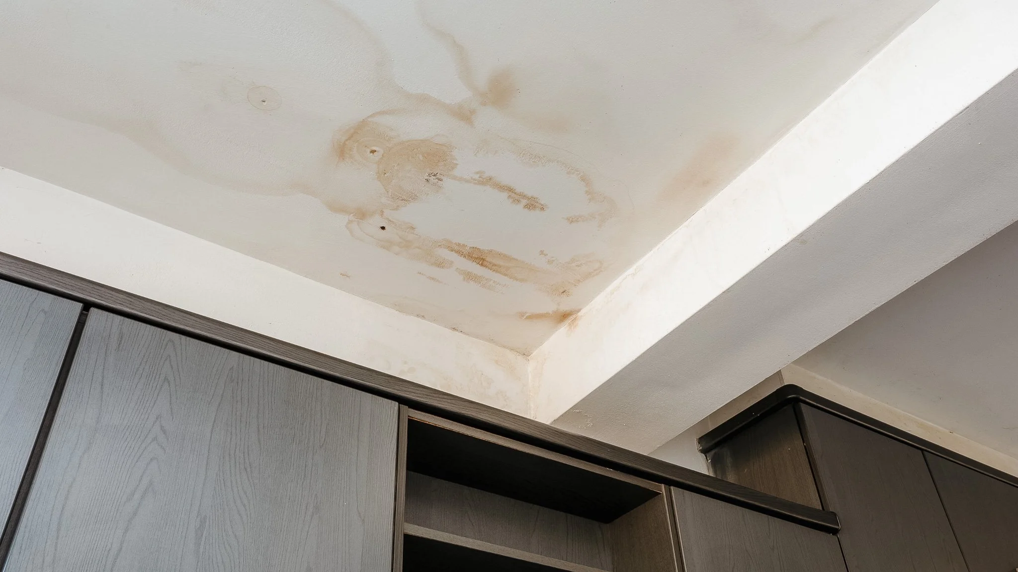 Ceiling water damage from roof leak in Pensacola home showing stains and moisture buildup