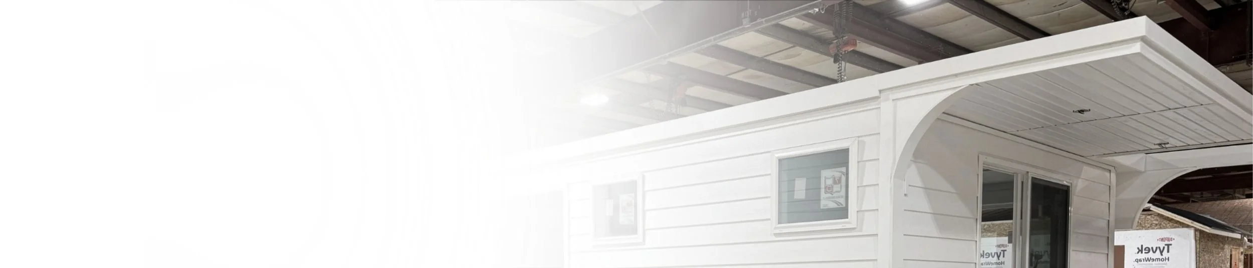 A modern white houseboat inside a factory