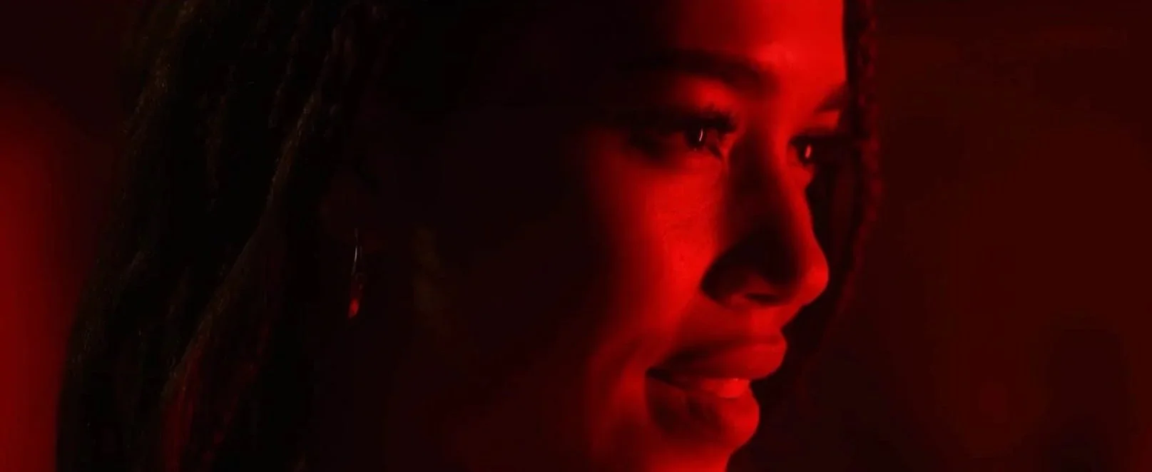 Savannah Bangoura in a red-lit dramatic film still.