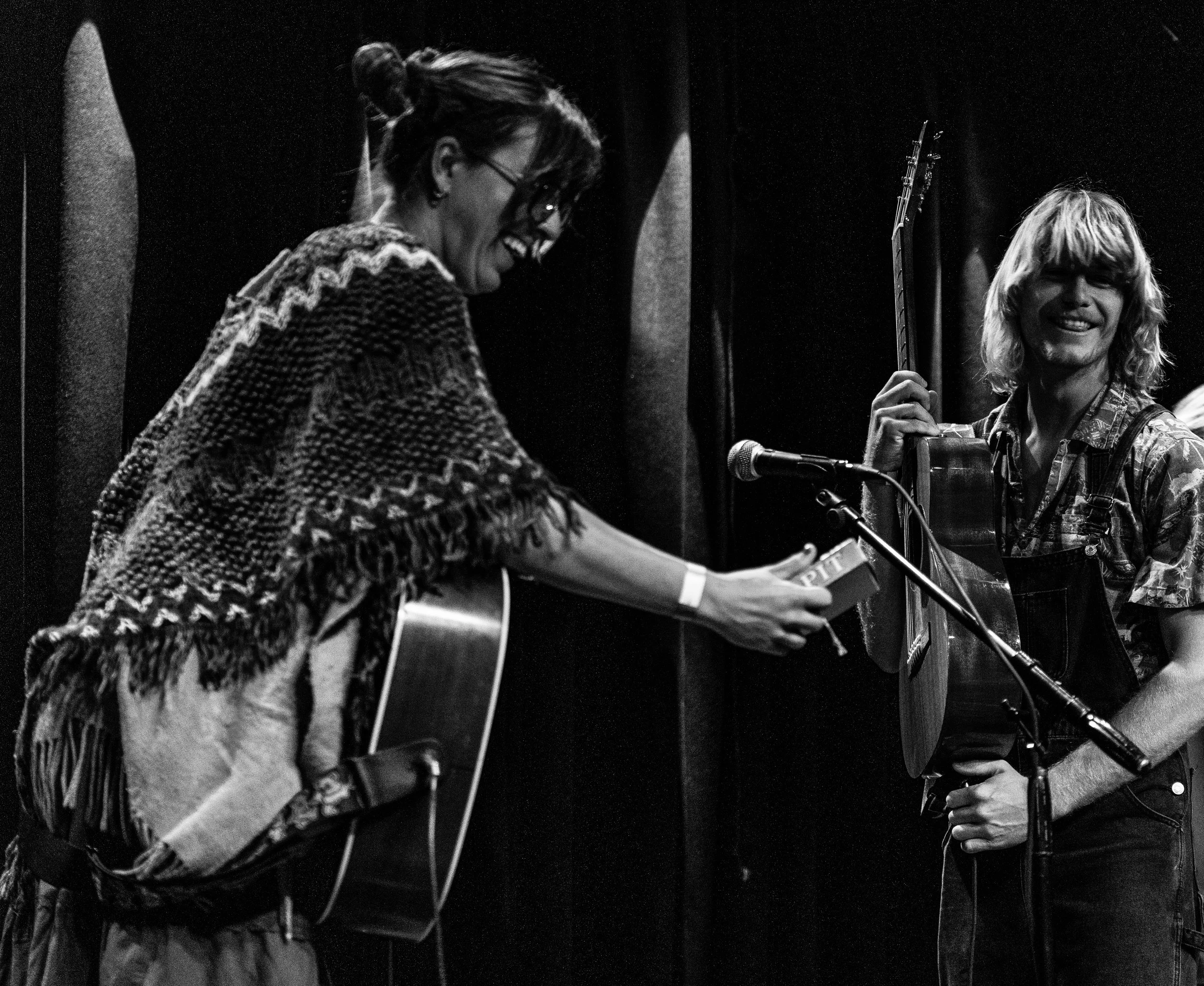 Toby Still and Carmen Wanderoni El Faye from Orange Pit, both smiling with guitars, a microphone, and stage equipment visible at SoHo House Santa Barbara.
