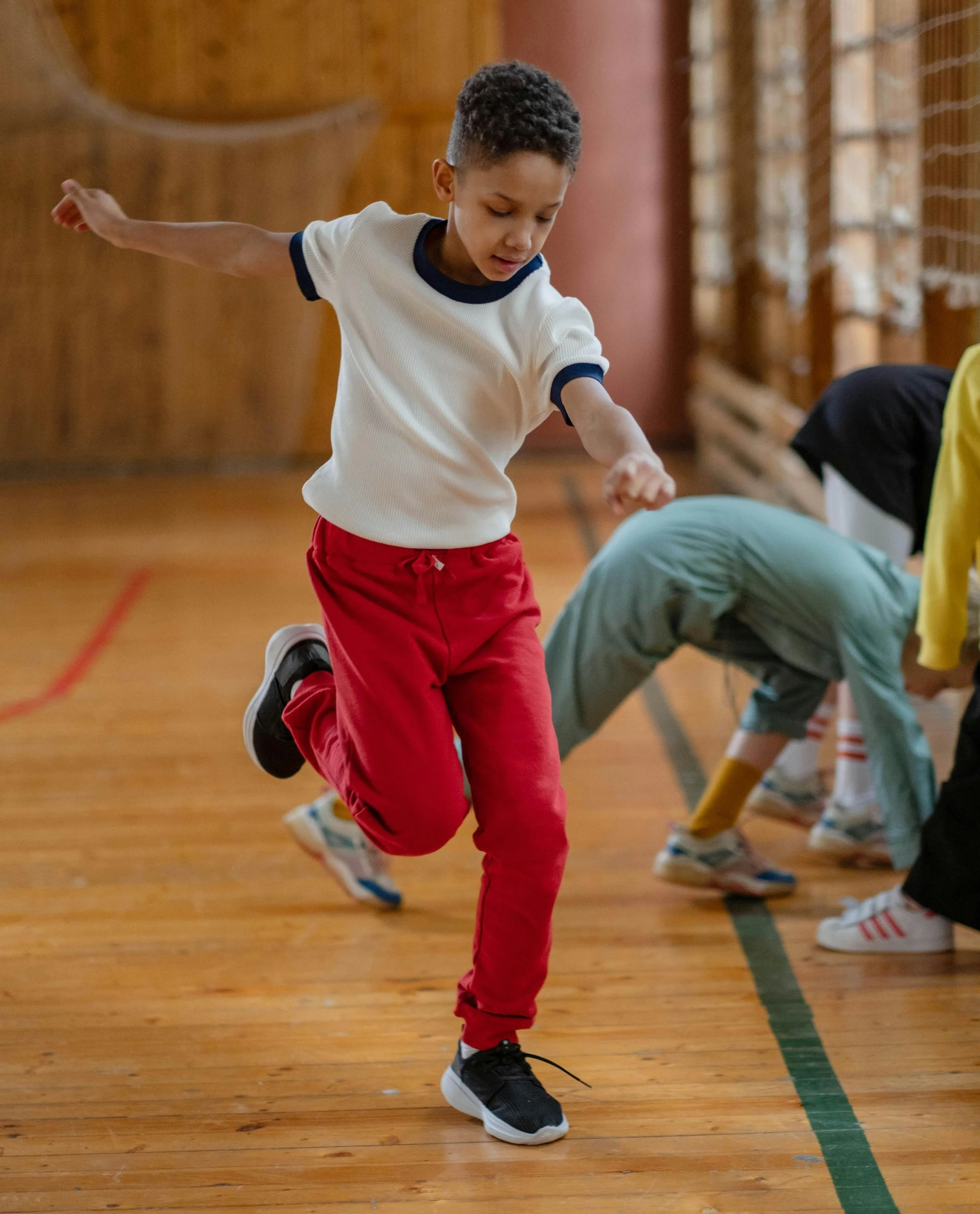 A child mid-run in a school gym.