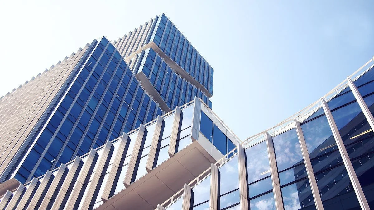 Modern building with blue glass windows against sky. GLO prepares and reviews Asset Purchase Agreements and assists with Business Purchases and Sales. Contact Geraghty Law Office: Real Estate & Business Law. Trusted Legal Support in Denver, Colorado.