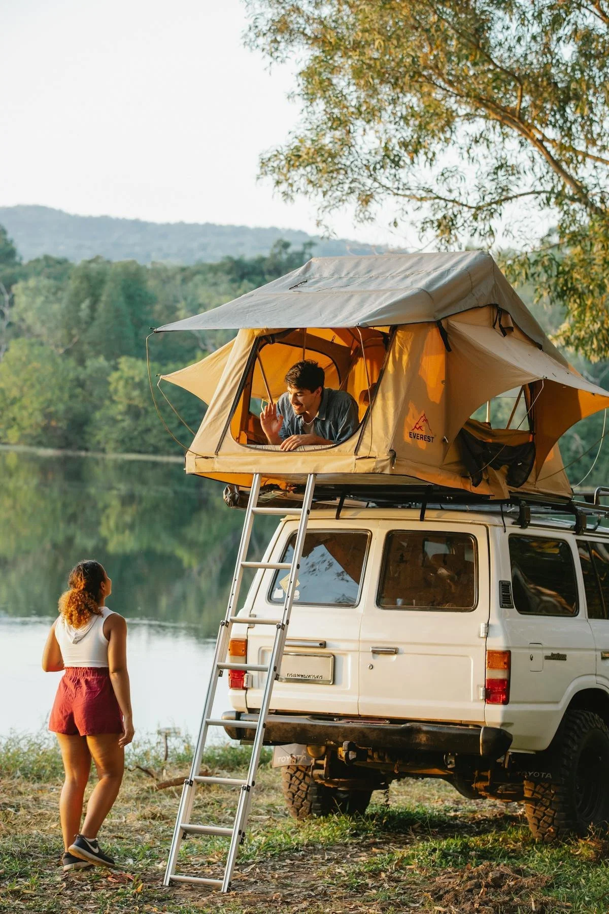 Child in rooftop tent on top of a truck, another person watching below. GLO assists with Mobile Home Park Transactions in Colorado. Contact Geraghty Law Office: Real Estate & Business Law. Trusted Legal Support in Denver, Colorado.