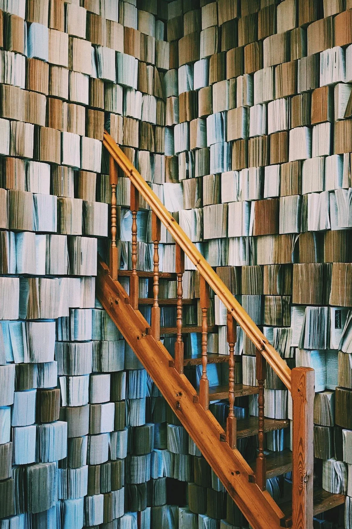 Wooden staircase against wall of books. Geraghty Law Office (GLO) provides trusted legal support in Denver, Colorado, advising business owners on contractual issues, including those related to verbal contracts.