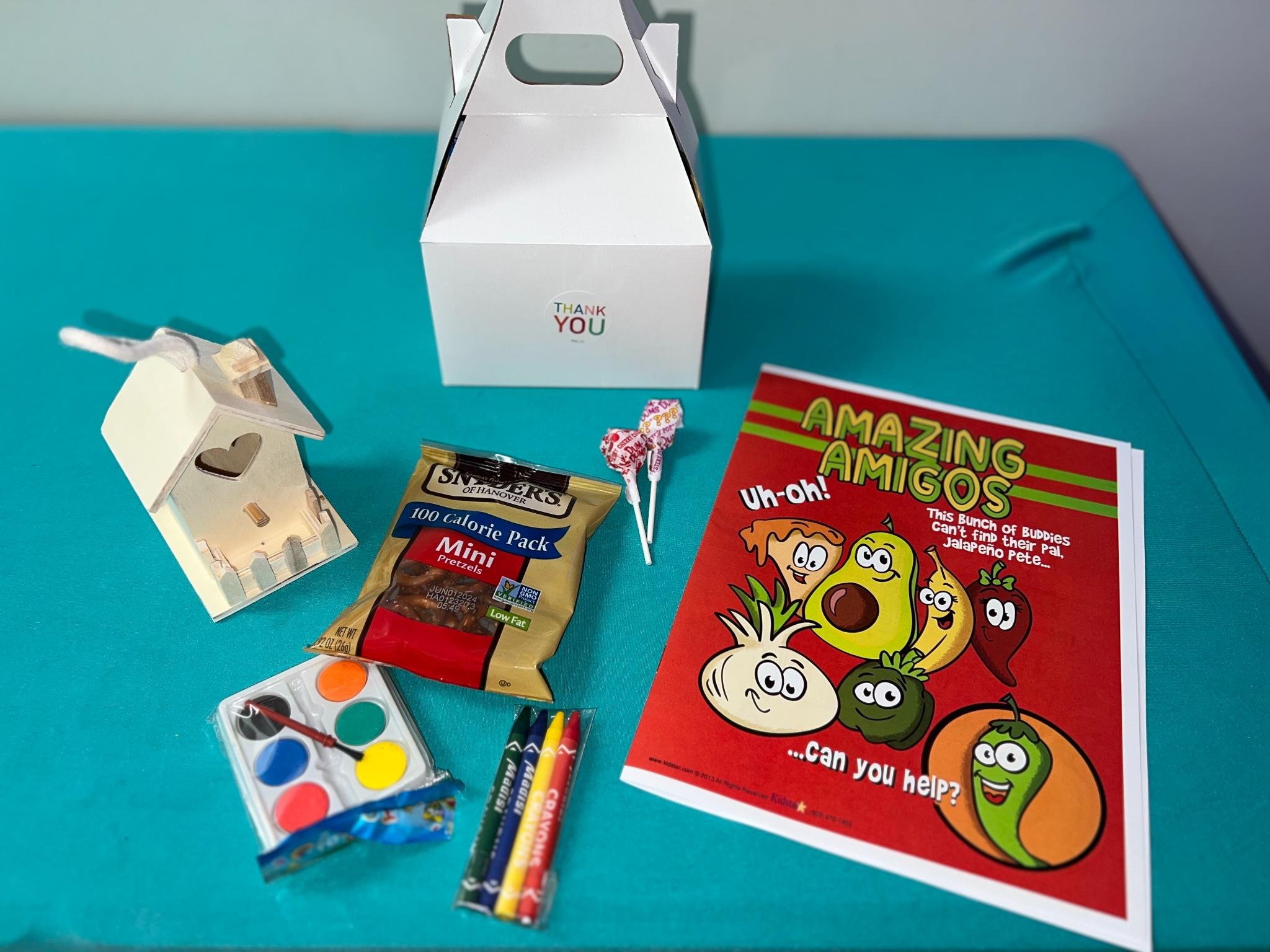 Extras: Goodie Bags: Whats inside? A white box with "Thank You" sticker, wooden house, watercolors, coloring book, crayons, pretzels, two lollipops.