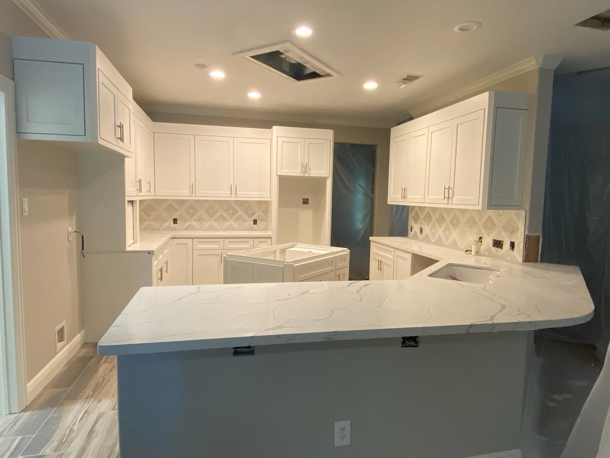 Oversized kitchen bar with white & gray quartz countertops installed, new backsplash & custom island with storage.