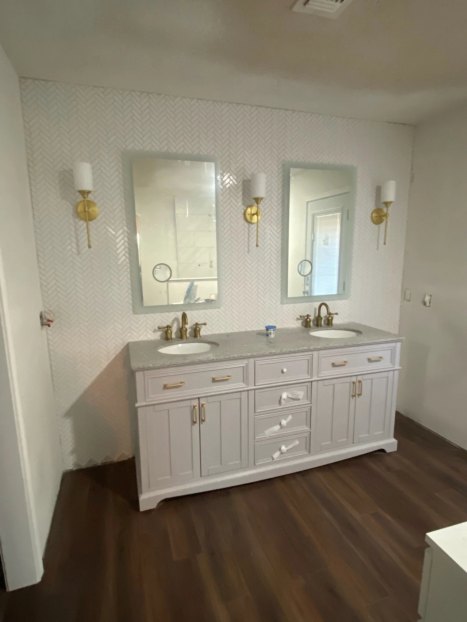 Bathroom renovation with new wood-look tile flooring, custom vanity, new countertop, lighting & hardware installation
