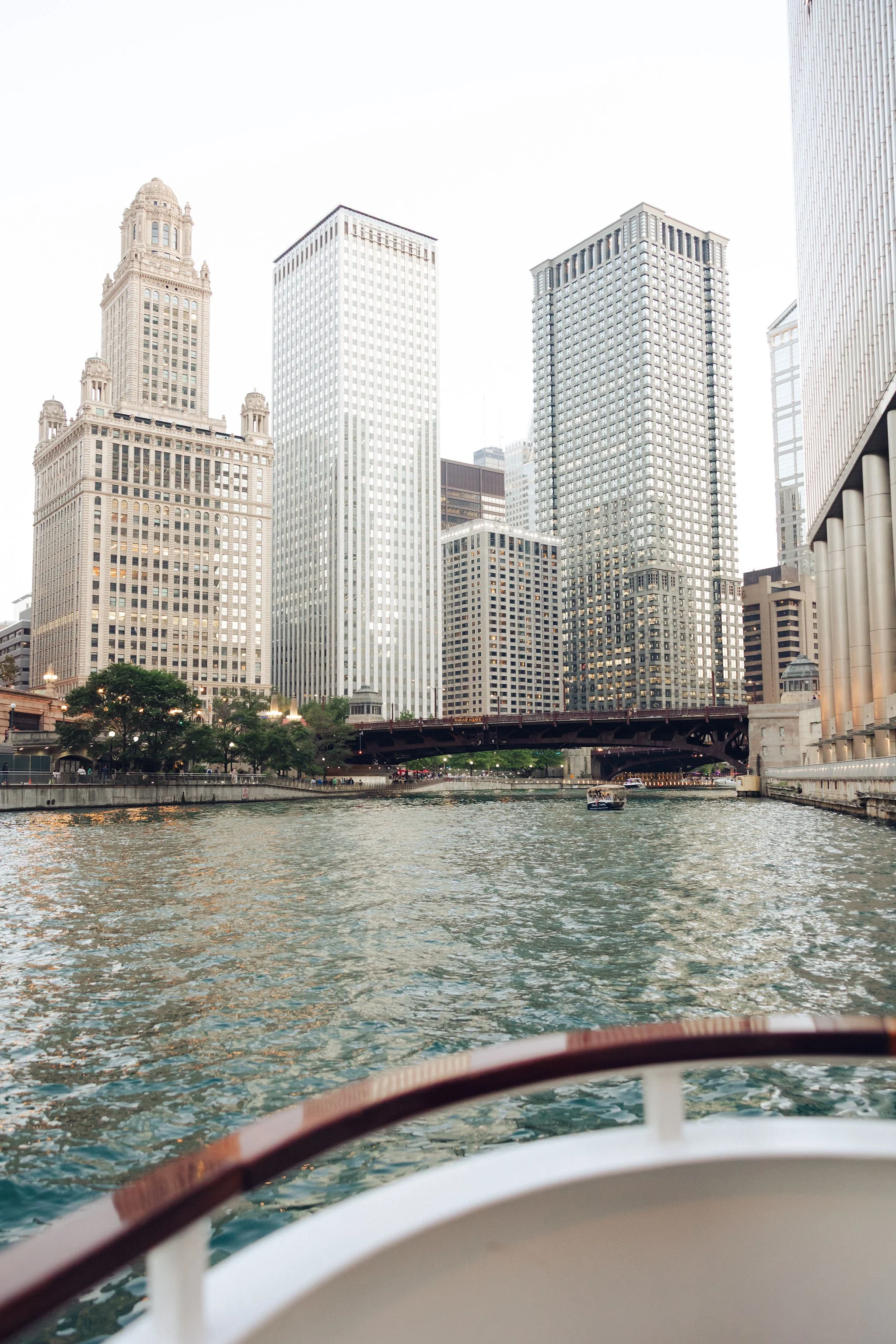 View of Chicago skyline with tall buildings along a river, as seen from a boat.