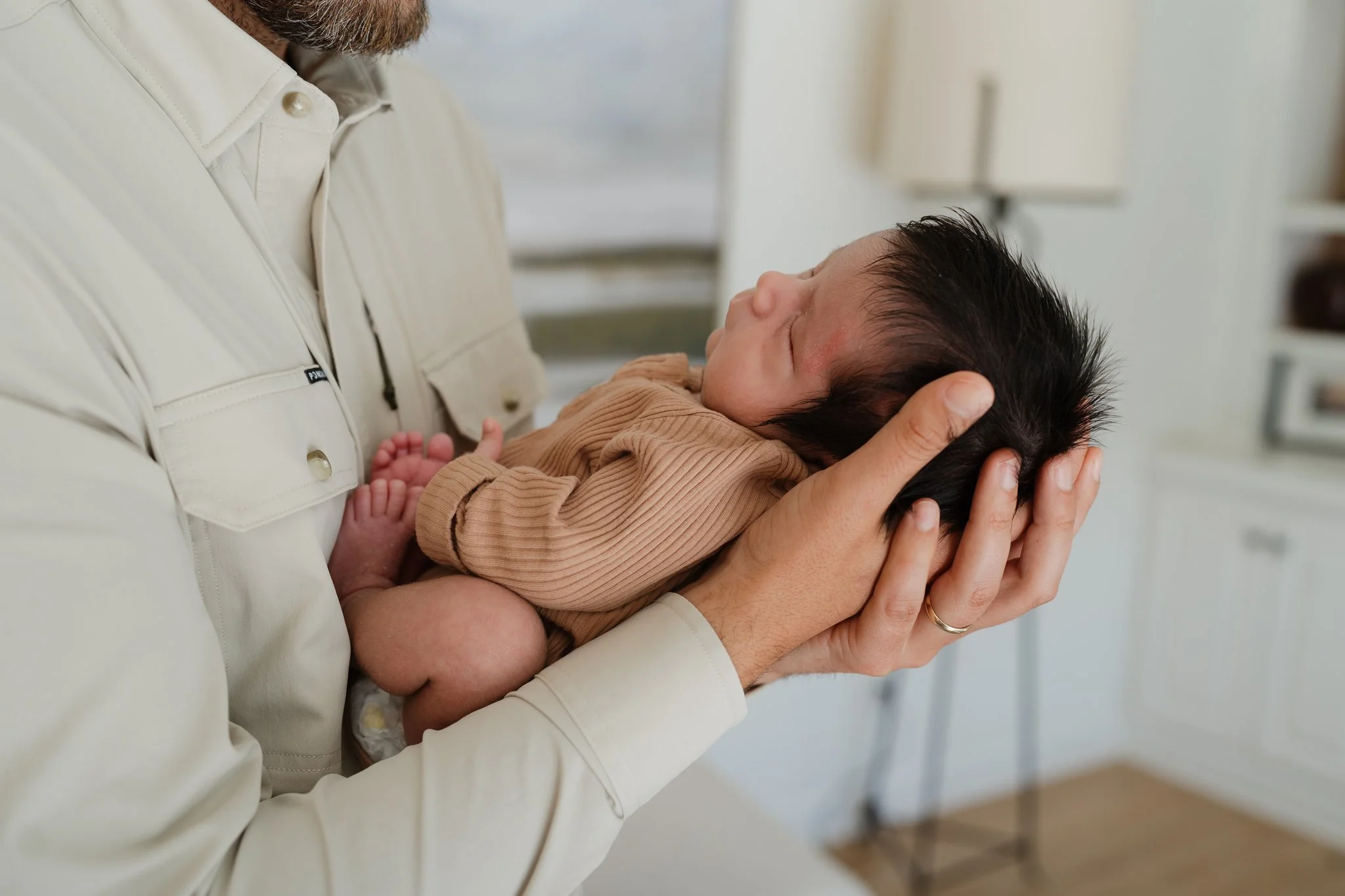 A person holding a sleeping baby in their hands, with the person's face partially visible and the baby resting peacefully in Memphis, TN. 