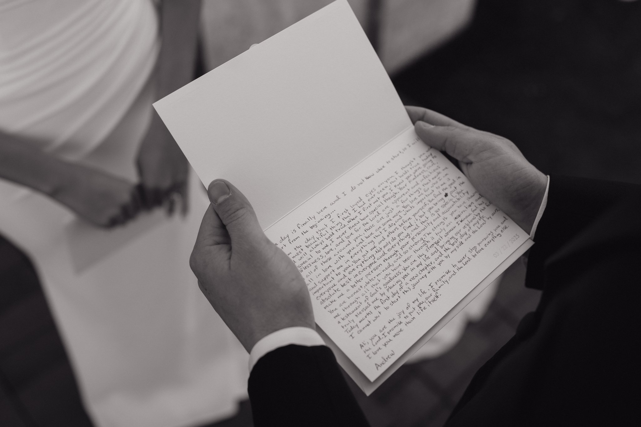 A person holding an open handwritten letter with both hands, with other people standing nearby in Memphis, TN. 