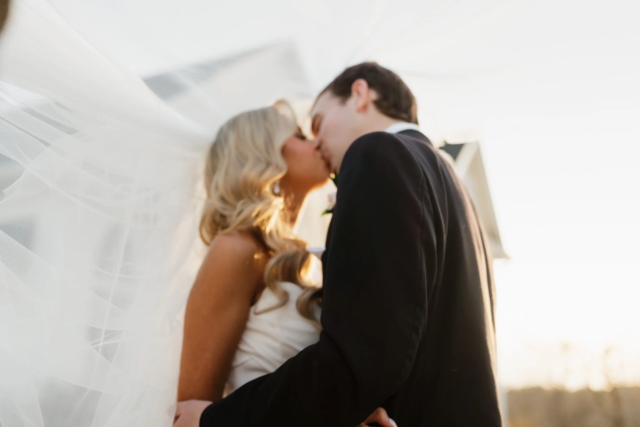 A bride and groom sharing a kiss outdoors during golden hour in Memphis, TN. 
