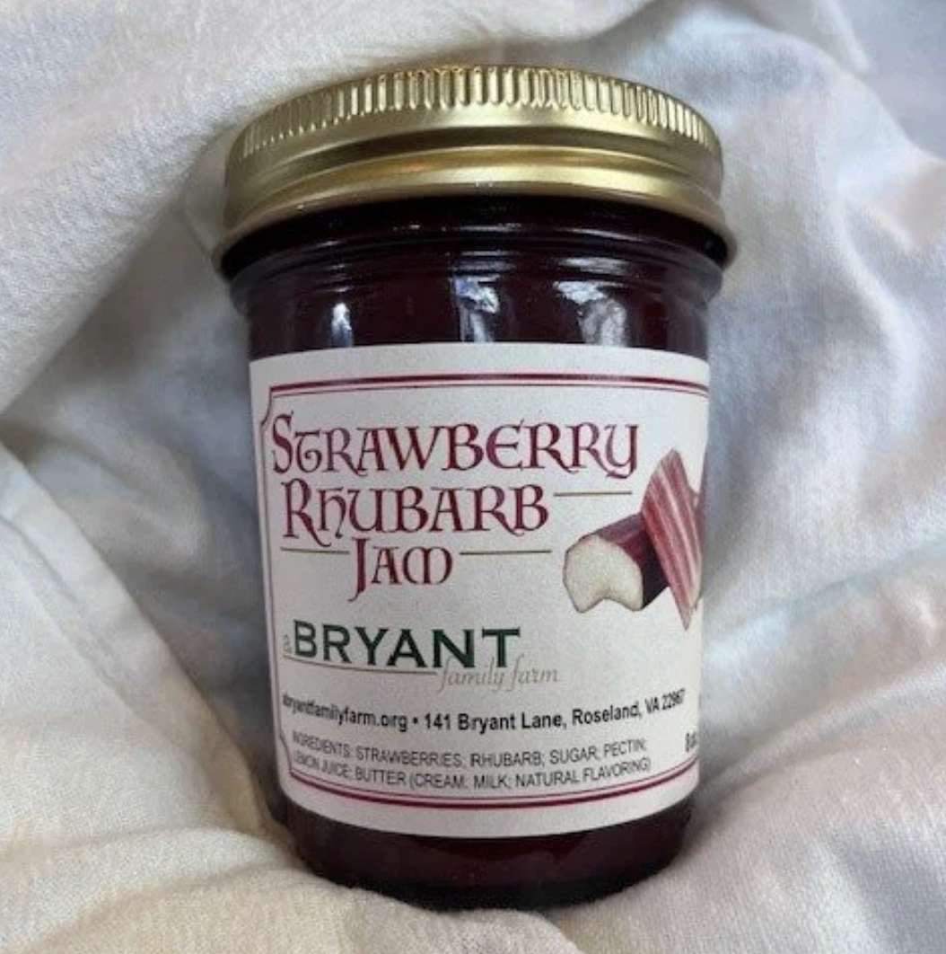 A jar of strawberry rhubarb jam from Bryant family farm, with a white background and a gold lid, labeled with ingredients and farm information.
