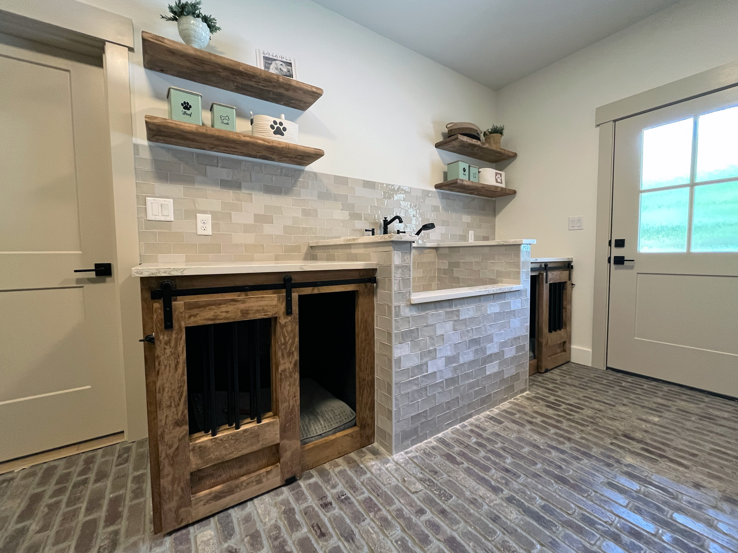 A cozy kitchen corner with floating wooden shelves, a small countertop area, and a sliding glass door letting in natural light.