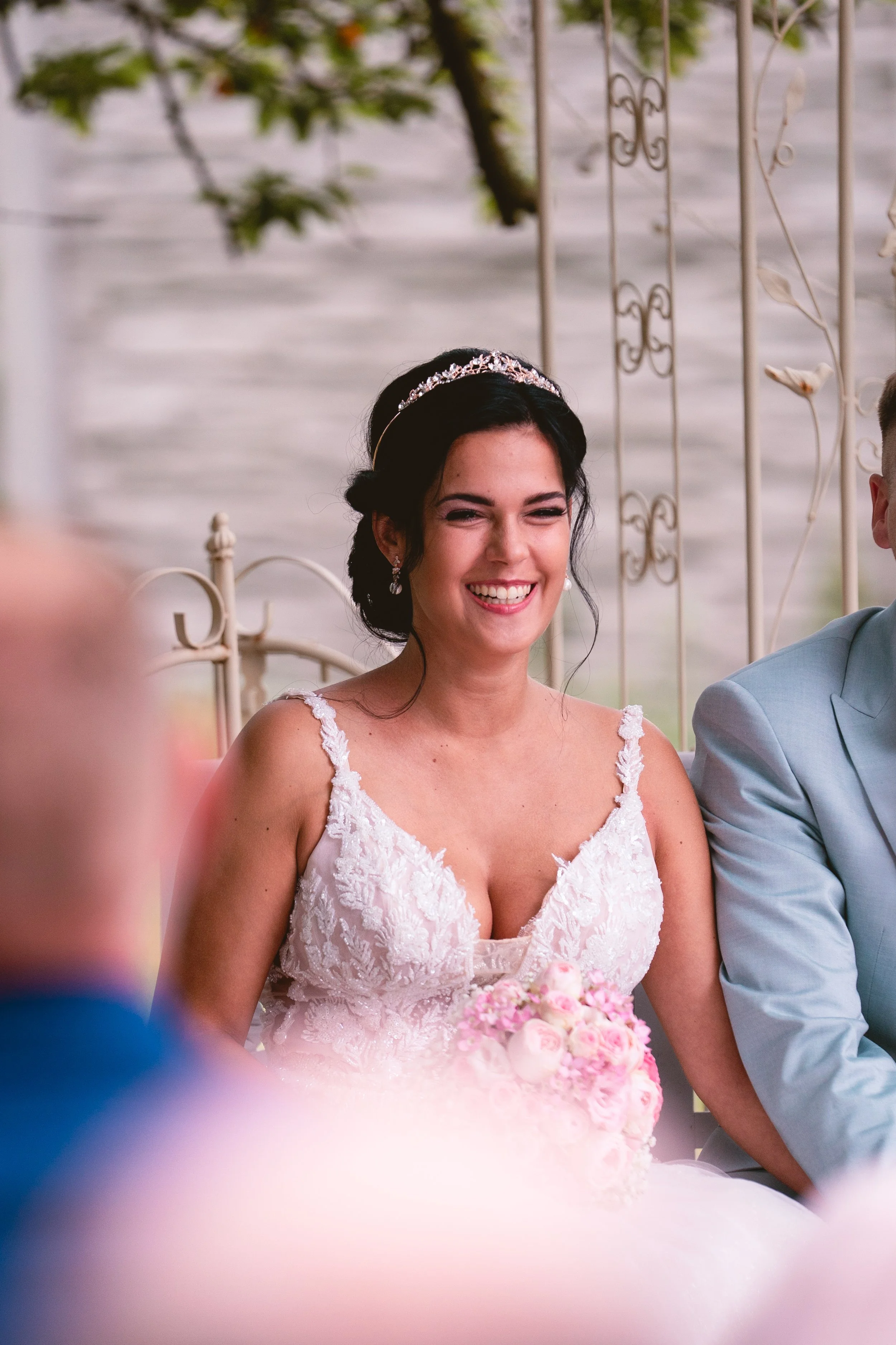 Junge Frau in Brautkleid mit Tiara beim Hochzeitstanz, hält einen Blumenstrauß.