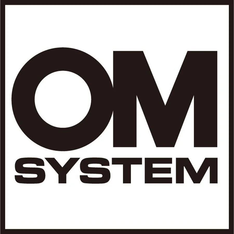 Schwarzes Logo mit weißen Hintergrund und der Aufschrift "OM SYSTEM" in großen, fetten Buchstaben.