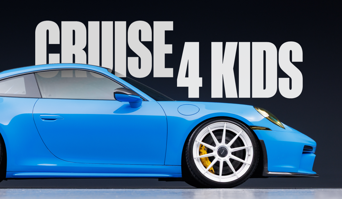 Blue sports car with white wheels and yellow brake calipers in front of a black background with large white text that reads 'Cruise 4 Kids'.