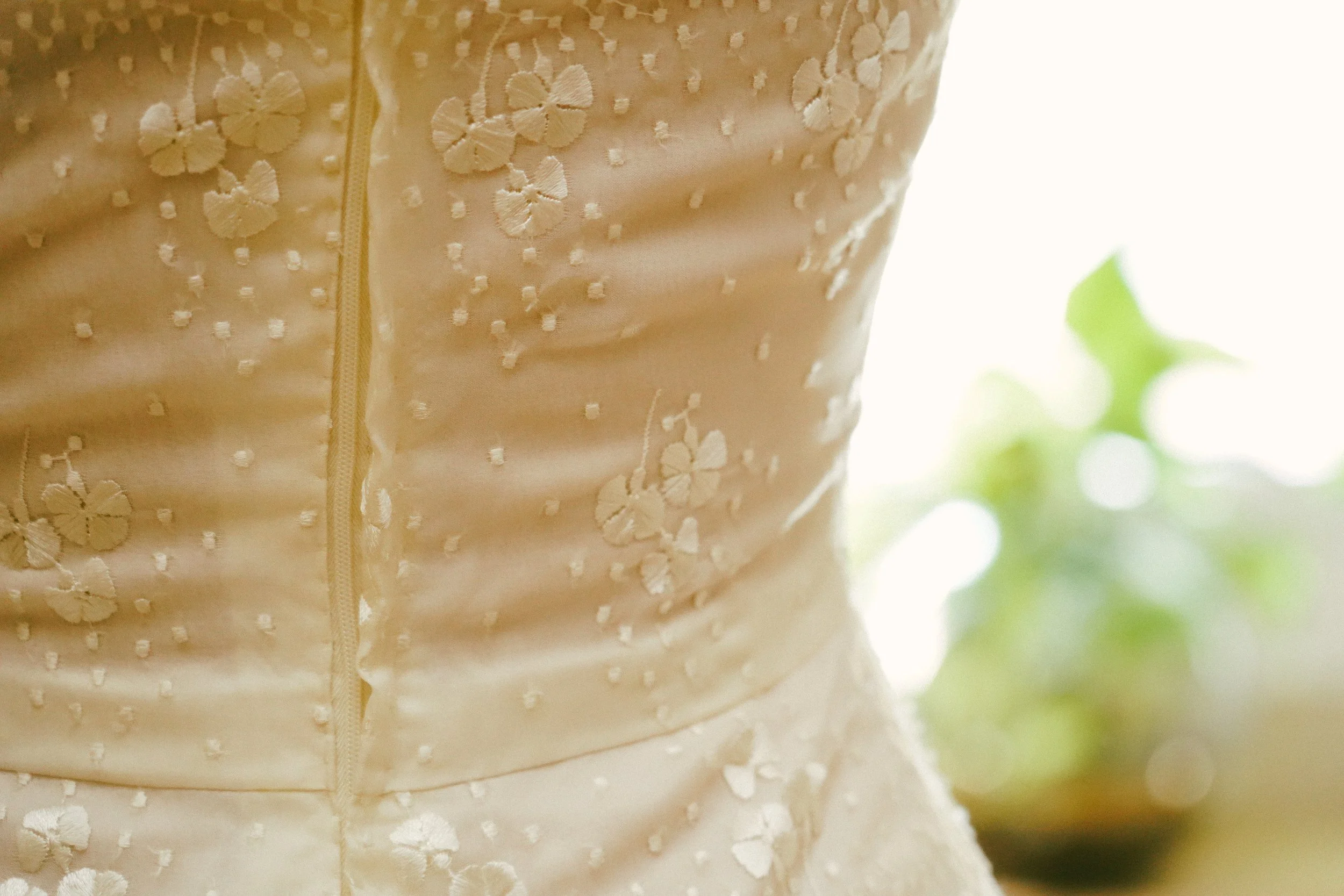Vestido de novia blanco con bordado de flores y detalles en relieve.
