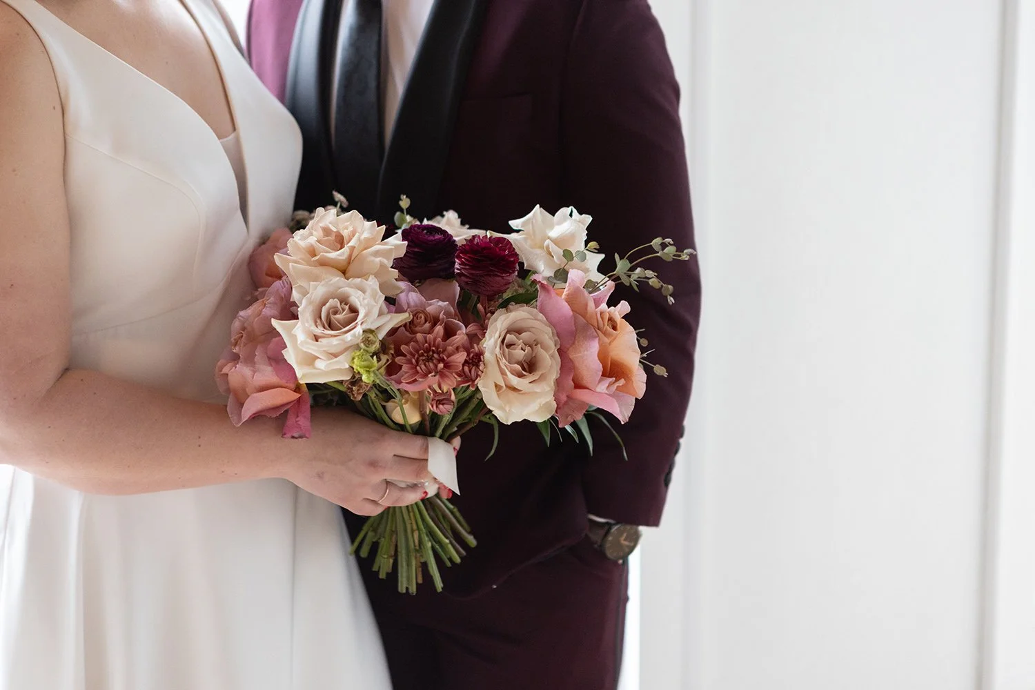 couple poses with flowers in front of windows at Tethered Events in South Loop Chicago