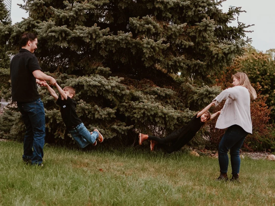 parents swinging their kids around in Airdrie Alberta