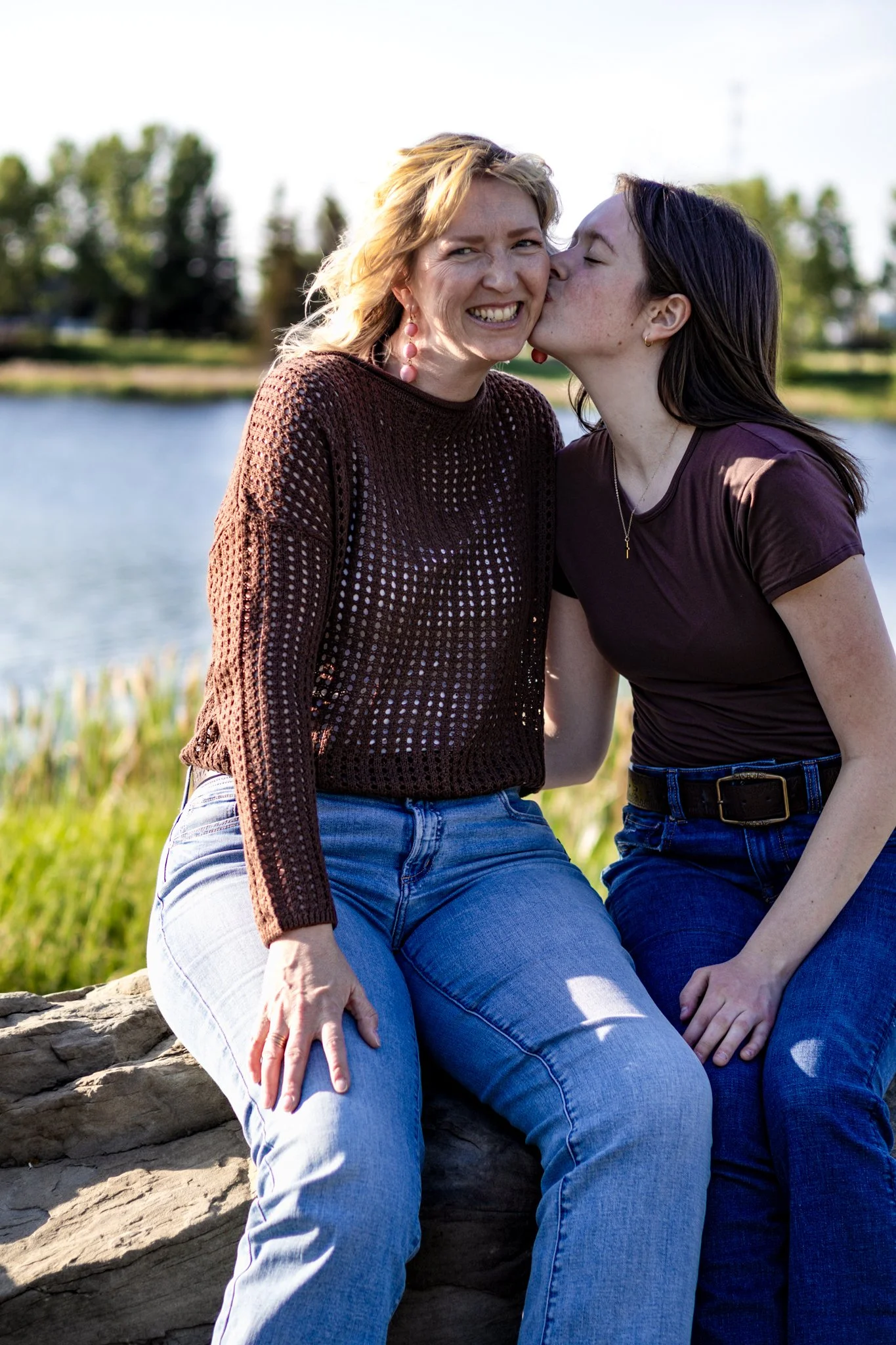 Mother and teenage daughter hugging in tall grass – Airdrie family photography session