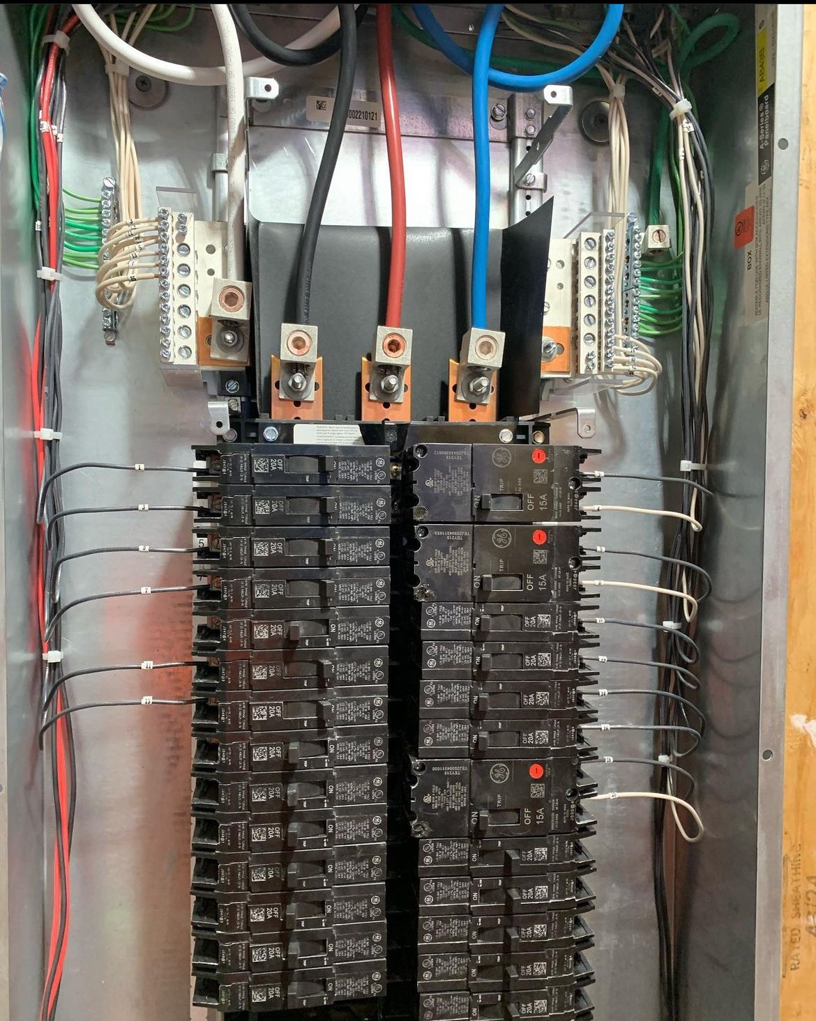 Inside an electrical panel with multiple circuit breakers, wiring, and bus bars.