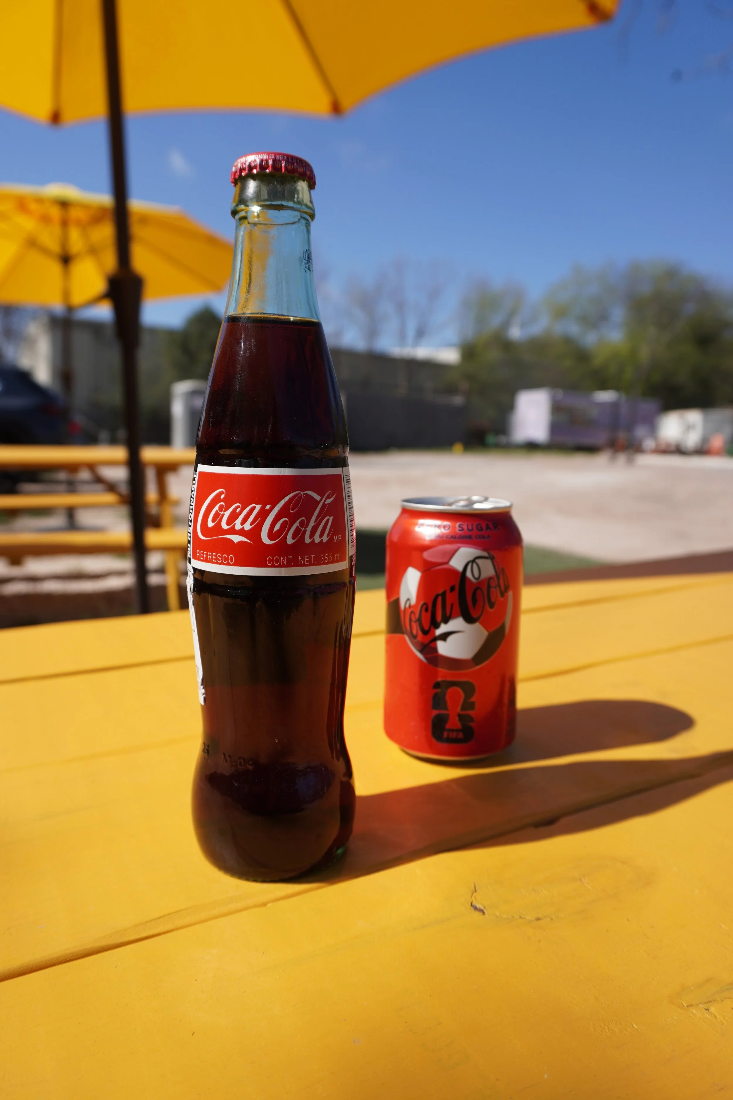 one mexican coke in glass bottle and one coke zero in a can
