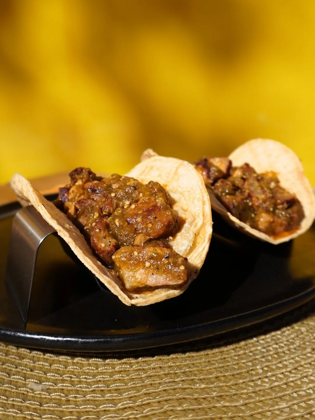 two corn tacos filled with chicharron verde