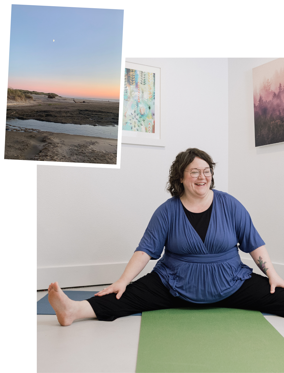 A woman practicing yoga indoors on a green mat, smiling while sitting in a wide-legged seated stretch. The room has white walls with colorful artwork hanging on them.