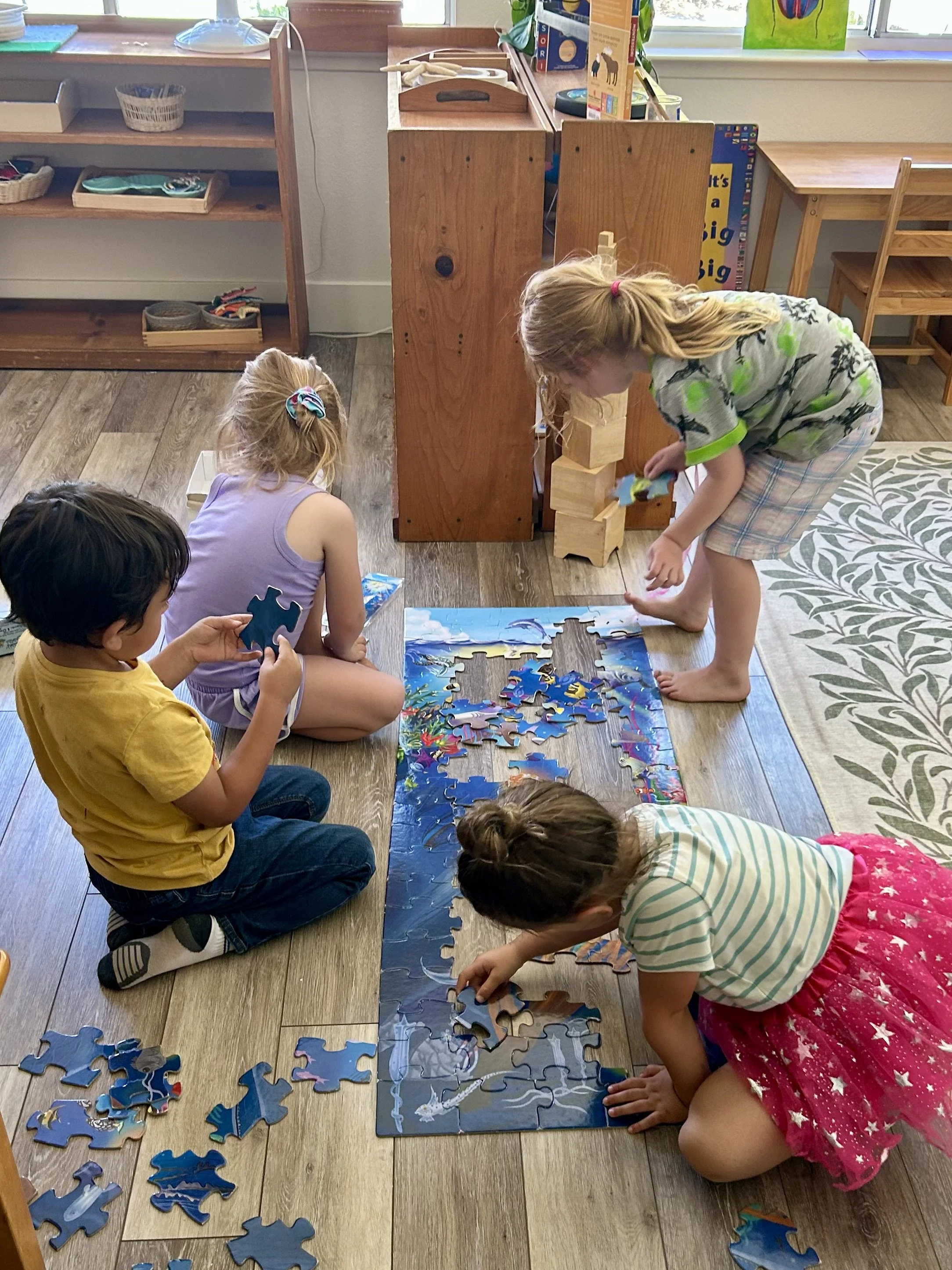 Preschoolers working on a puzzle together
