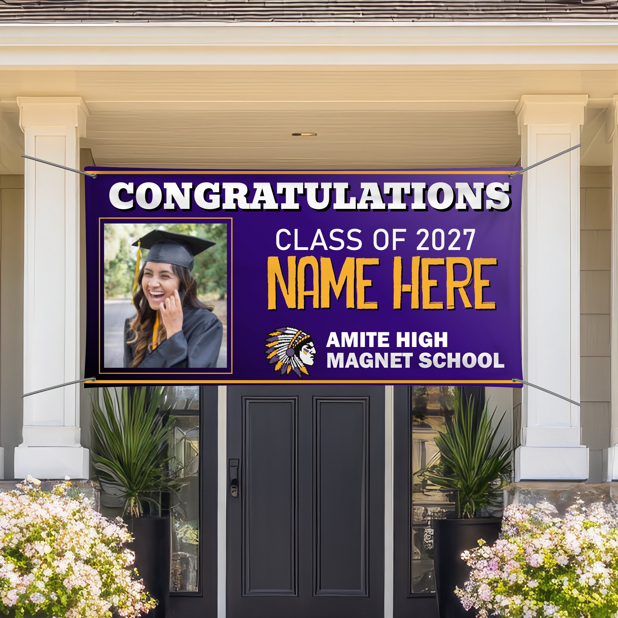 A large purple congratulatory banner for a high school class of 2027 with a photo of a smiling young woman in graduation cap and gown, displayed in front of a house with white pillars and plants at the base.