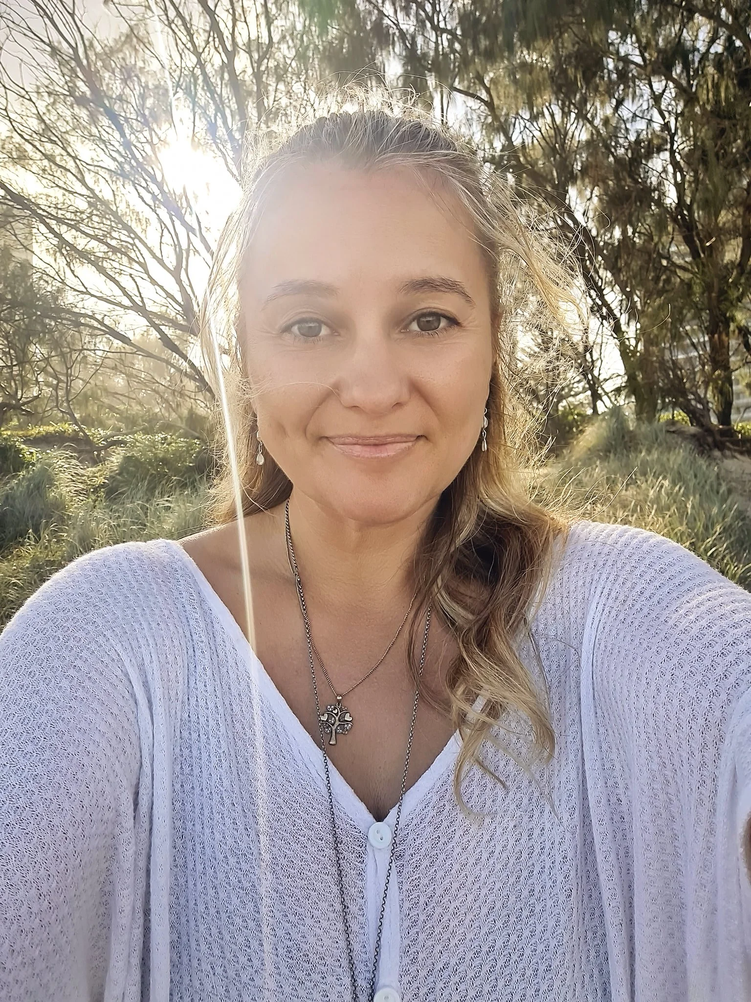 Maja Szumylo, naturopath on the Gold Coast, smiling outdoors at sunrise.