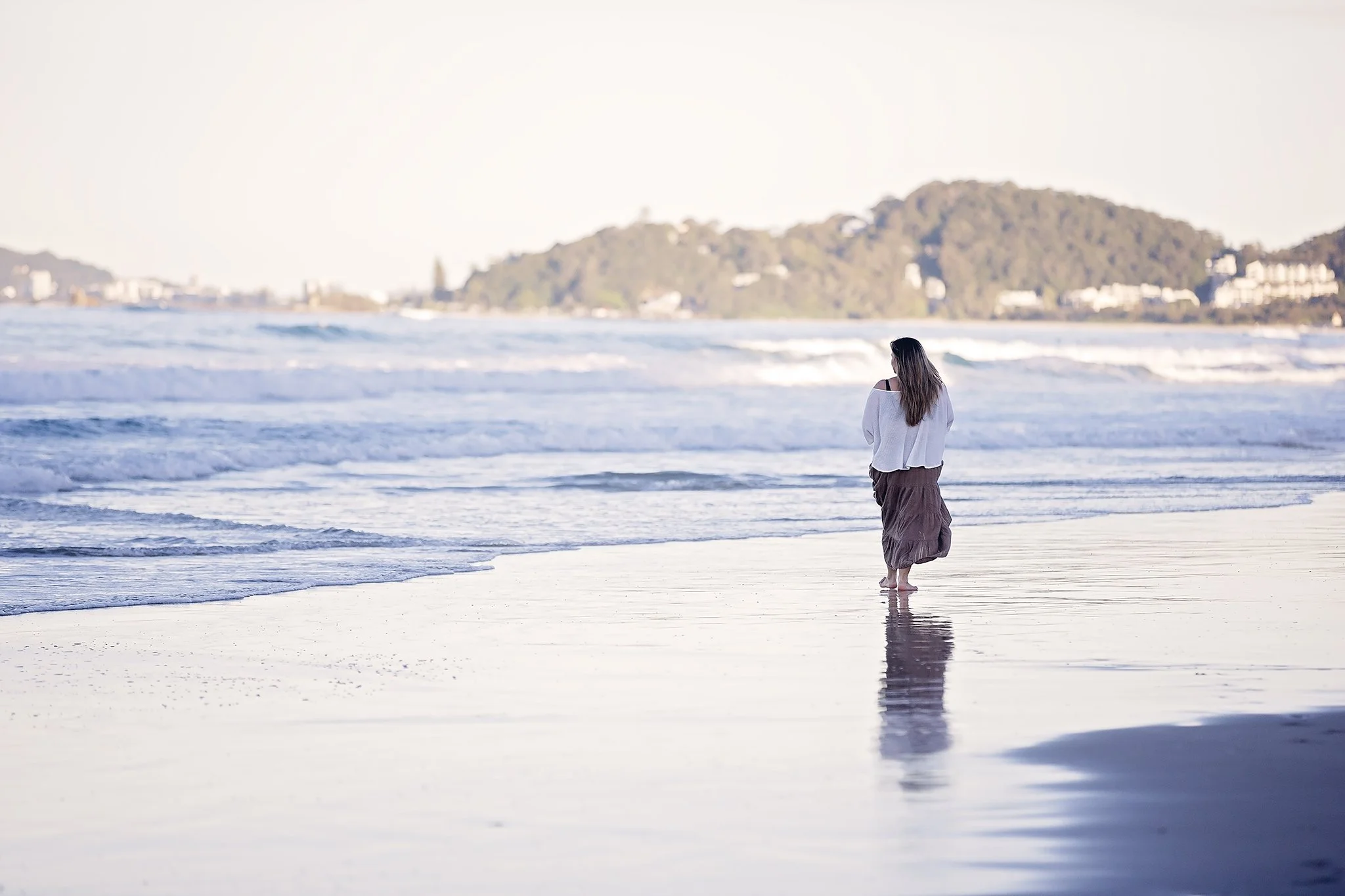 Woman walking on the beach at sunset — Maja Szumylo, Gold Coast naturopath.