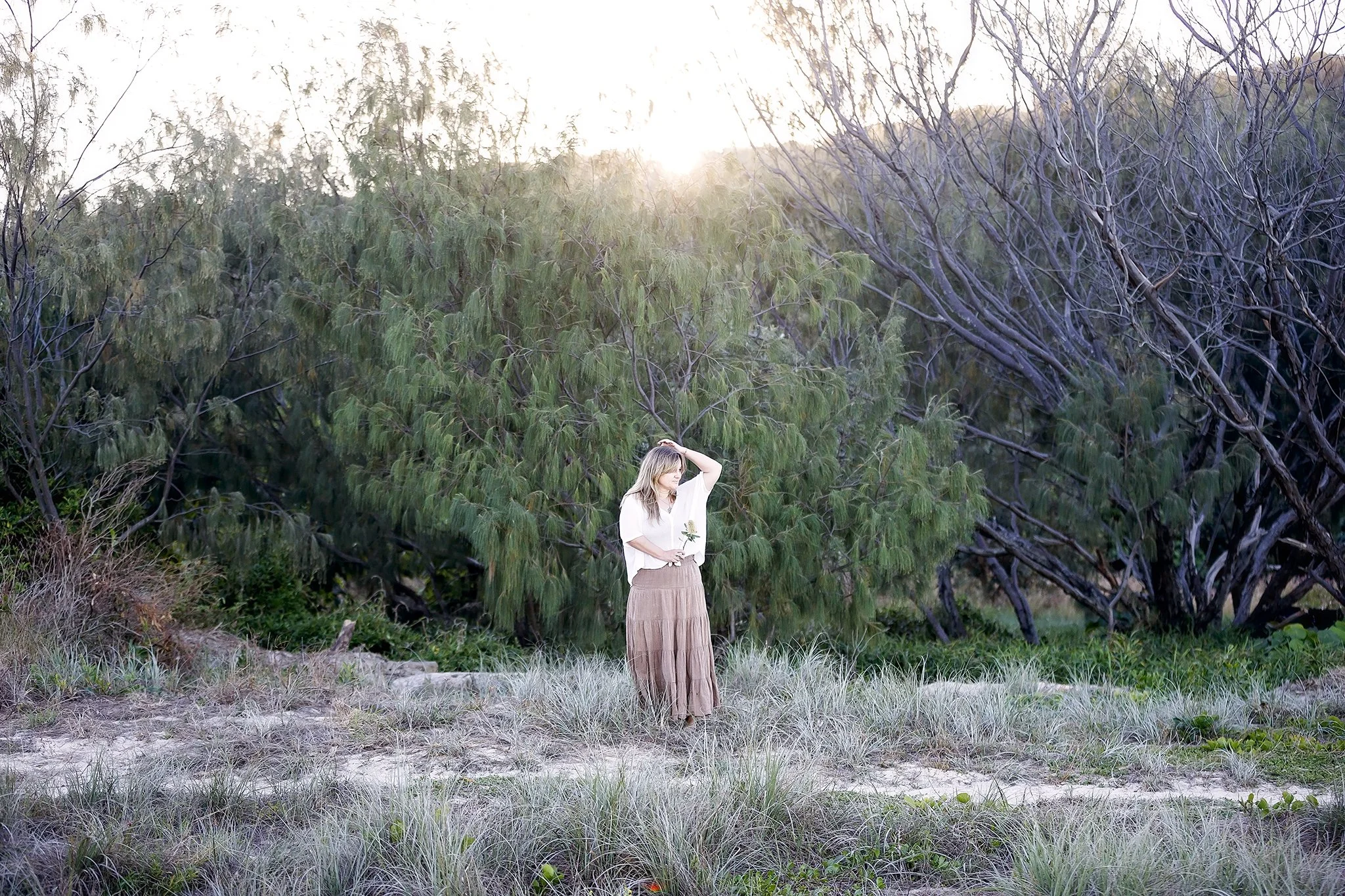 Maja Szumylo, naturopath on the Gold Coast, standing in coastal bushland at sunrise.