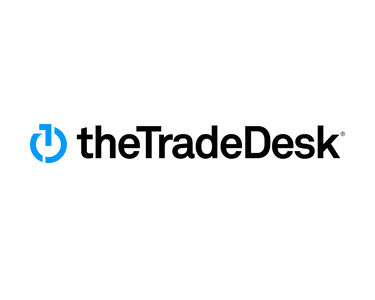 Logo with a light blue computer power button symbol before black text that reads "the Trade Desk".