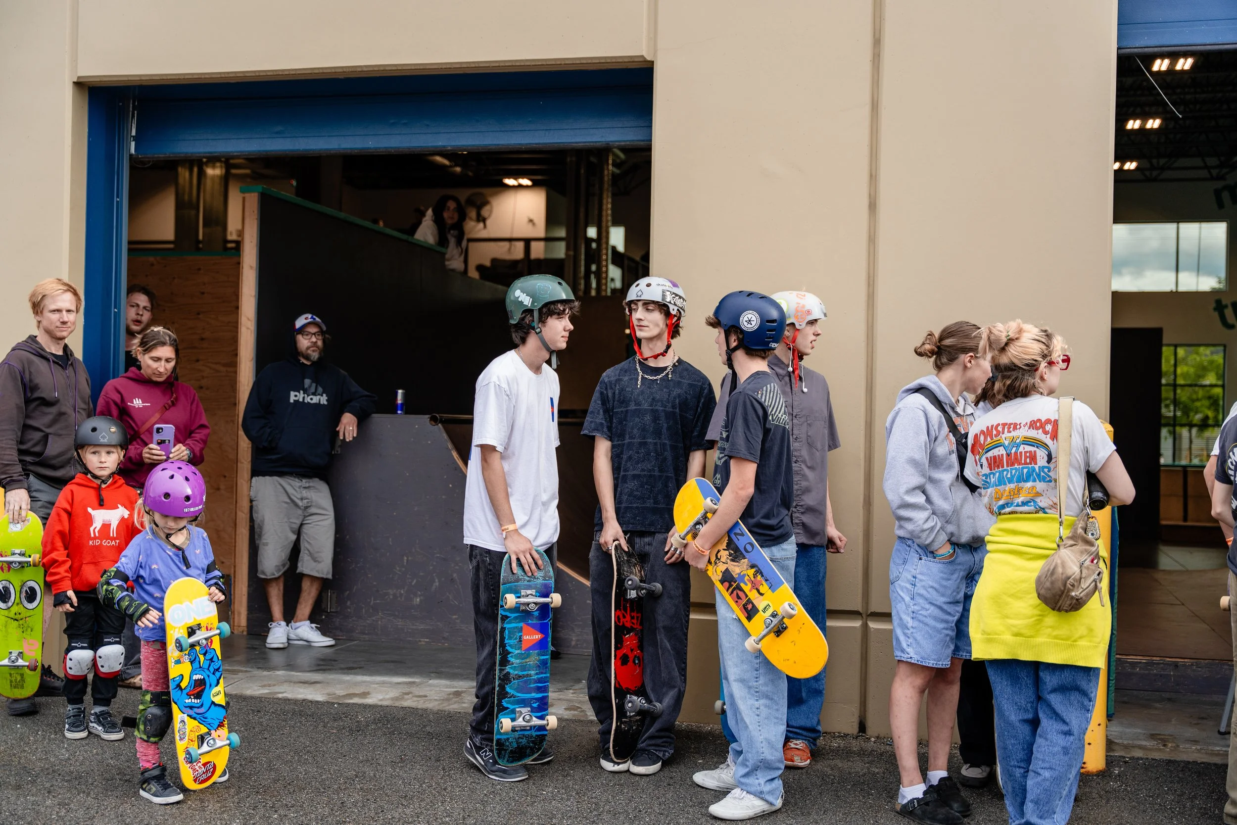 Skateboarders and spectators gathered outside an indoor skatepark