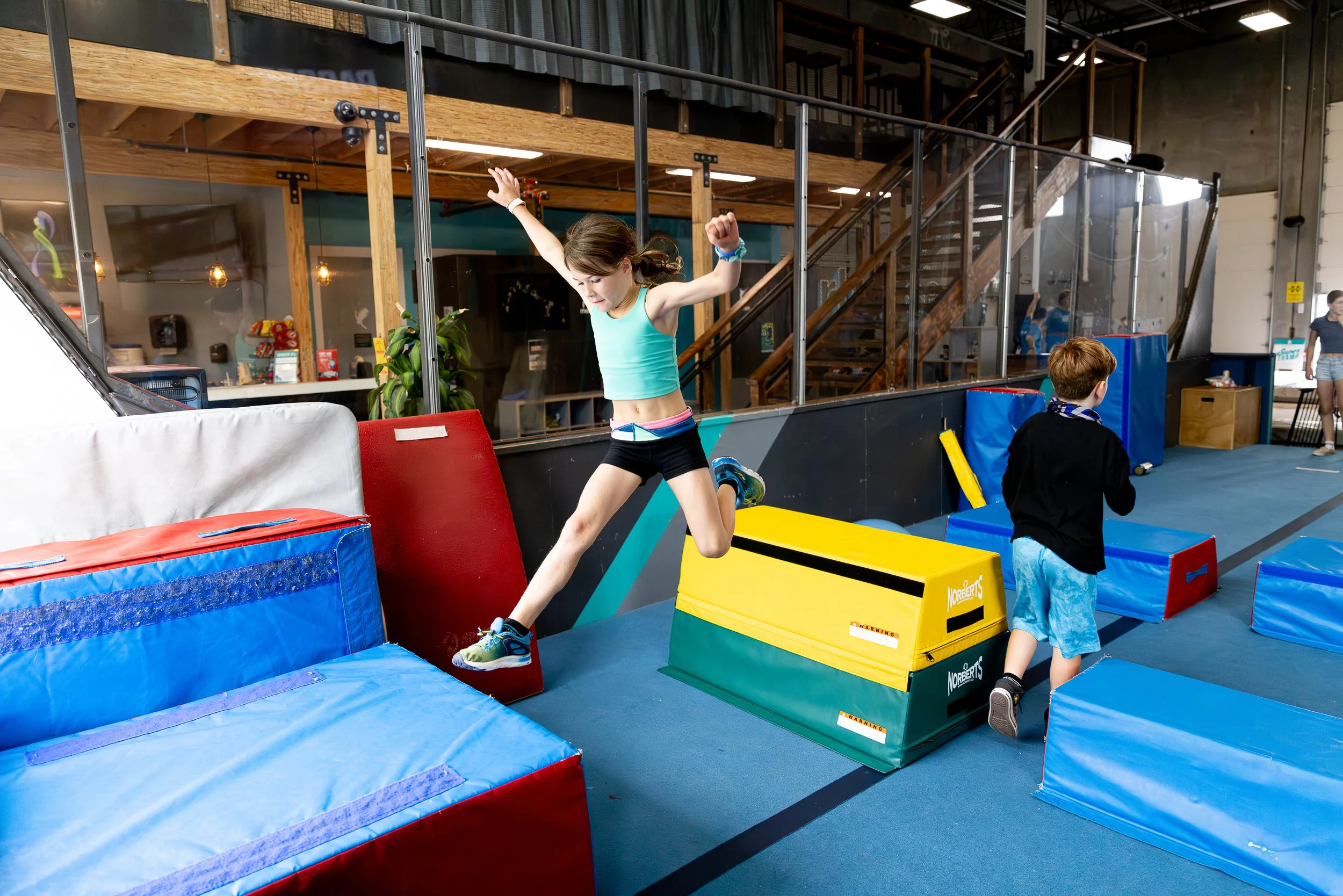 Children playing and jumping on foam padded obstacles at an Indoor freestyle training trampoline, gymnastics and parkour facility