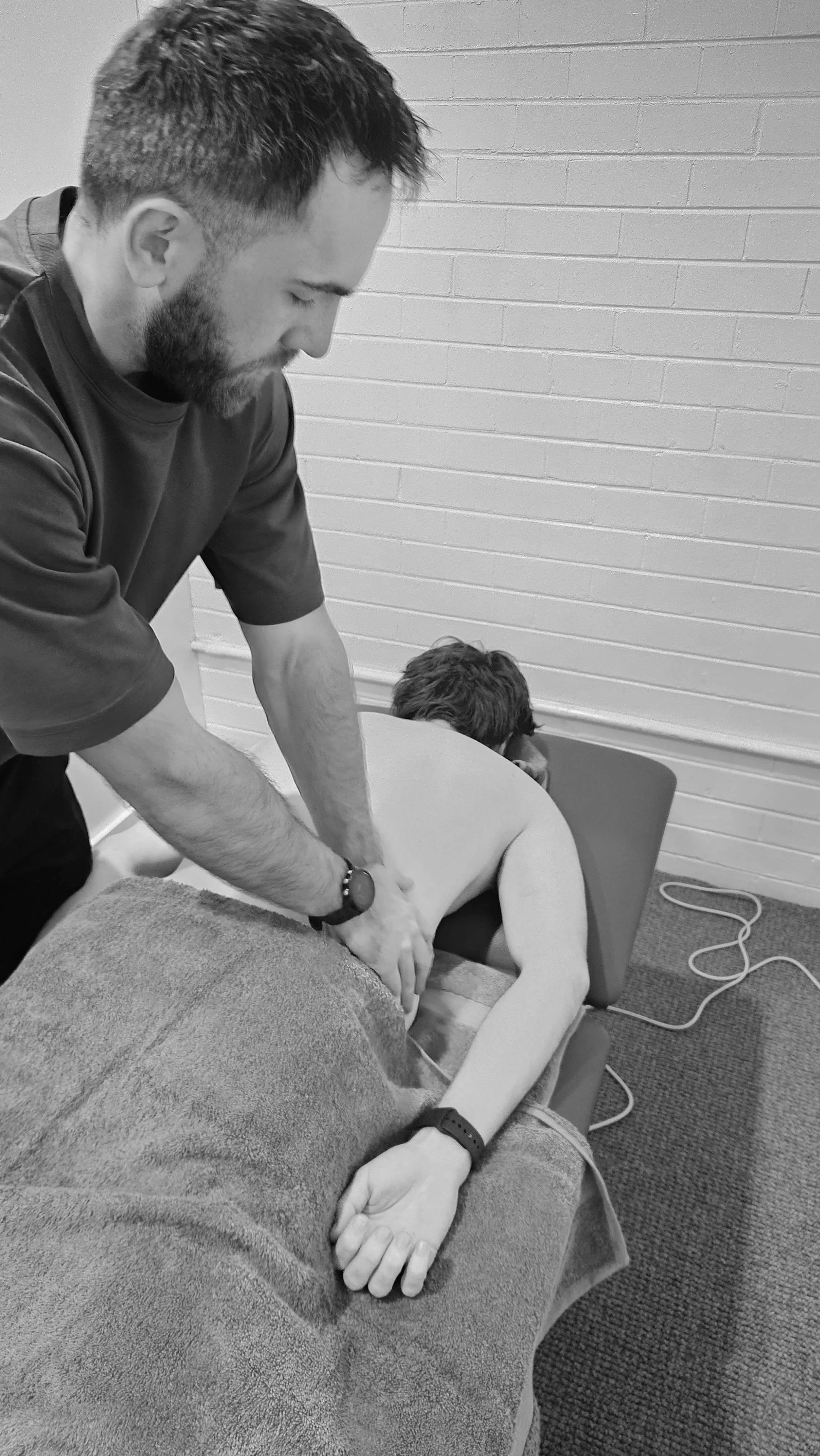 Dr Ryan Vaux massaging patient with lower back pain