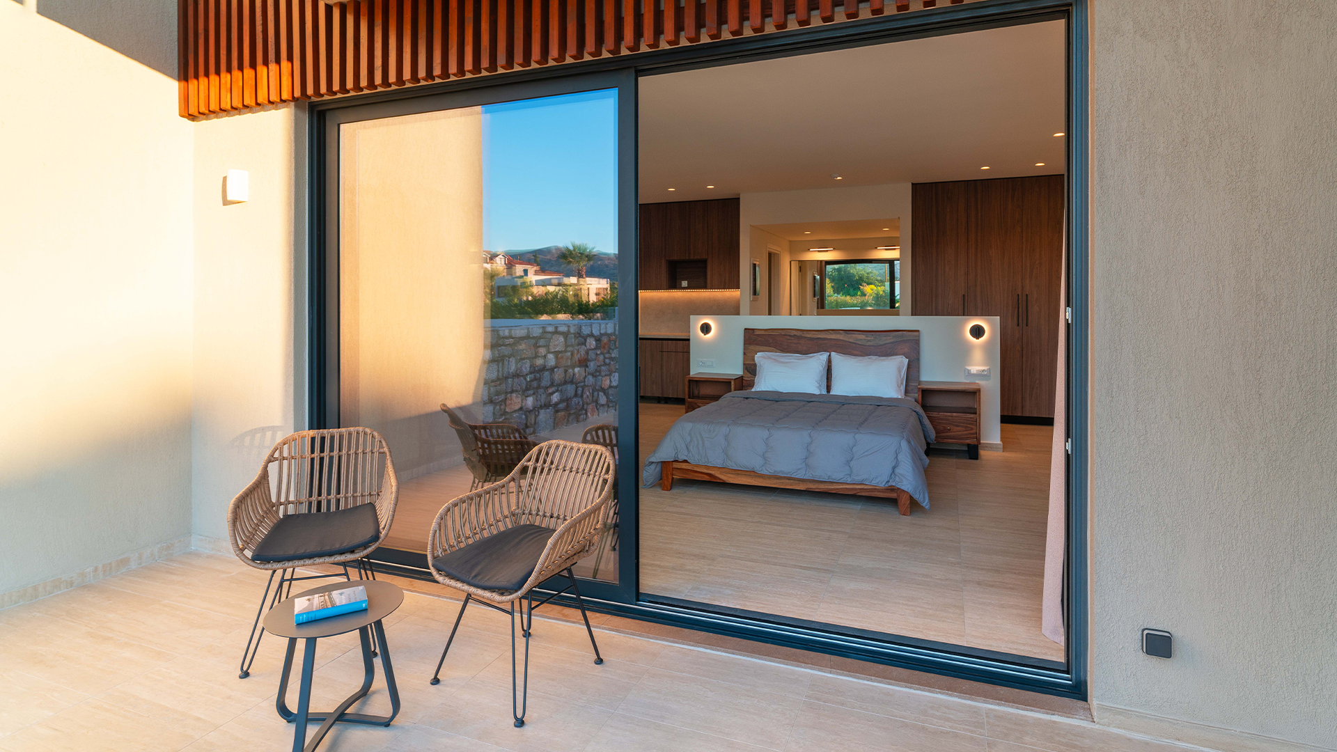 Rhodes suite overlooking a bedroom, wooden furniture, and large windows.