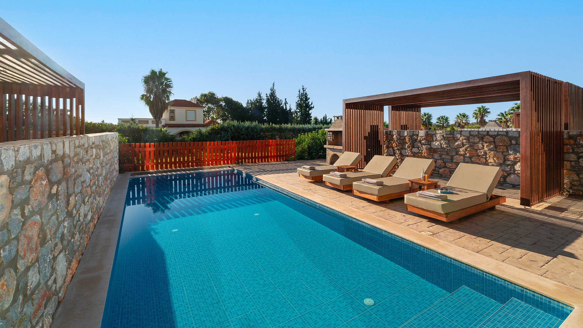 Rhodes Villa Luxury outdoor swimming pool with sun loungers and shaded cabana on a sunny day