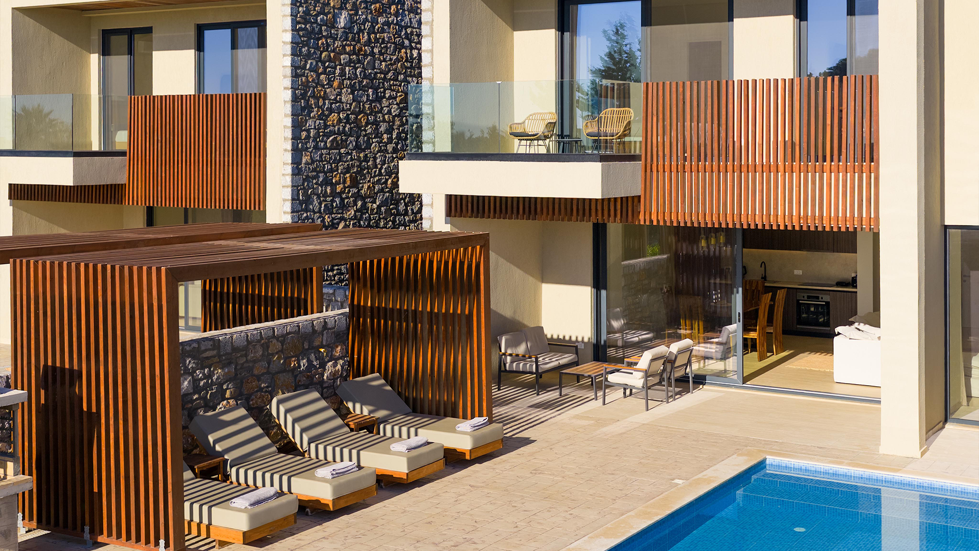 Rhodes Sea View Villa swimming pool, sun loungers, and outdoor seating areas under a bright blue sky.