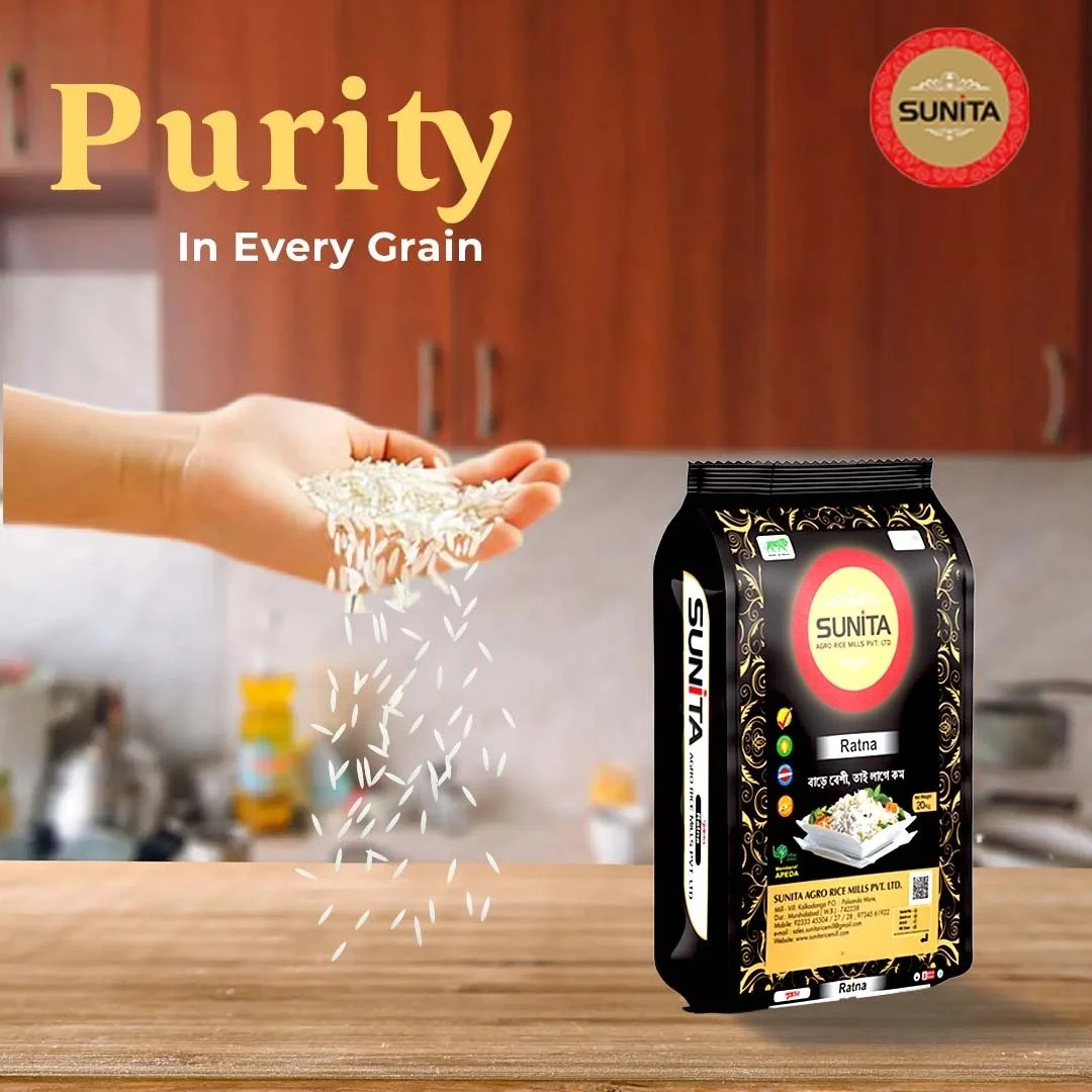 A hand holding rice with rice grains falling onto a wooden surface, adjacent to a black package of Sunita rice in a kitchen setting.