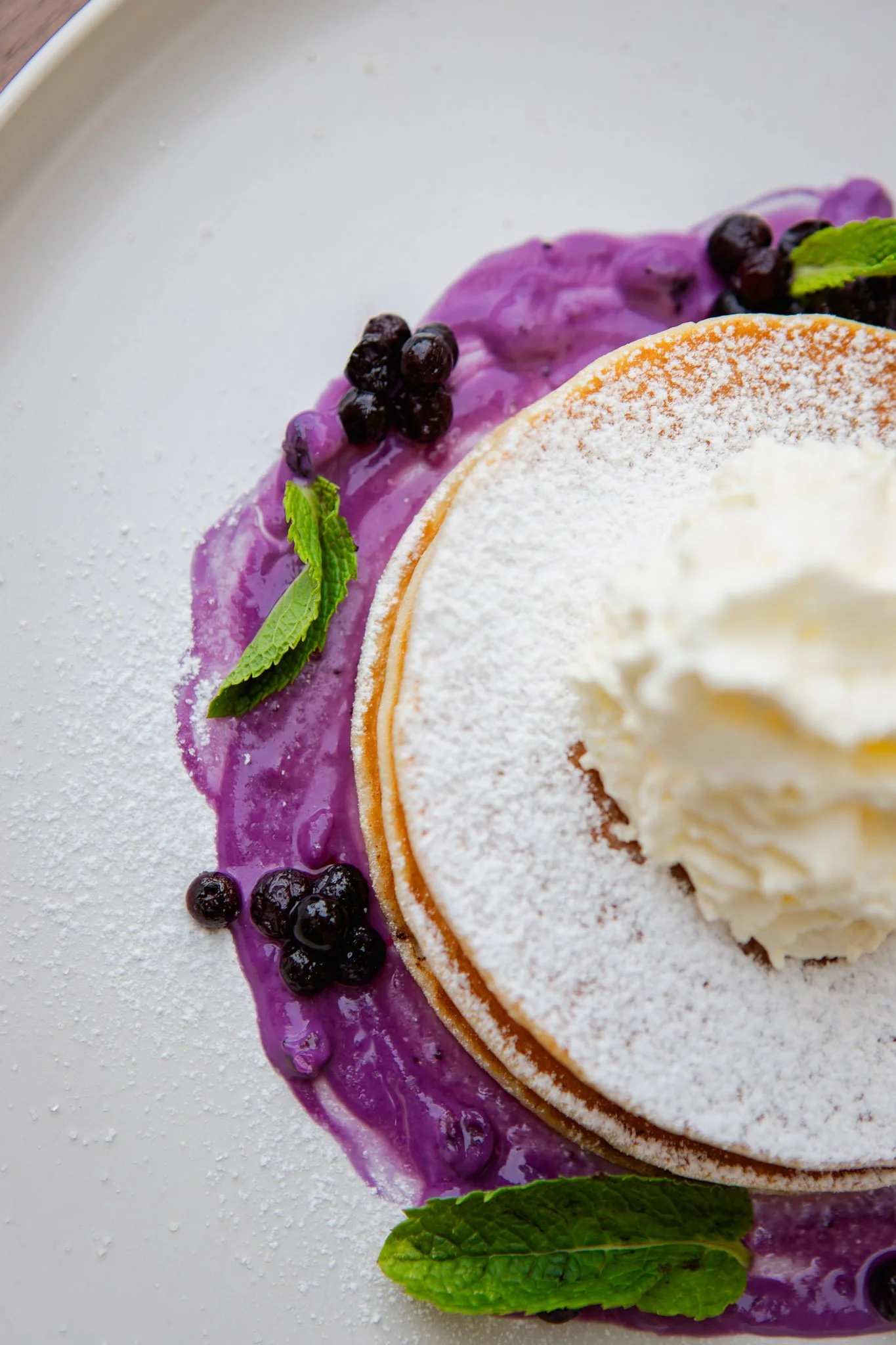 Blueberry pancake topped with whipped cream.